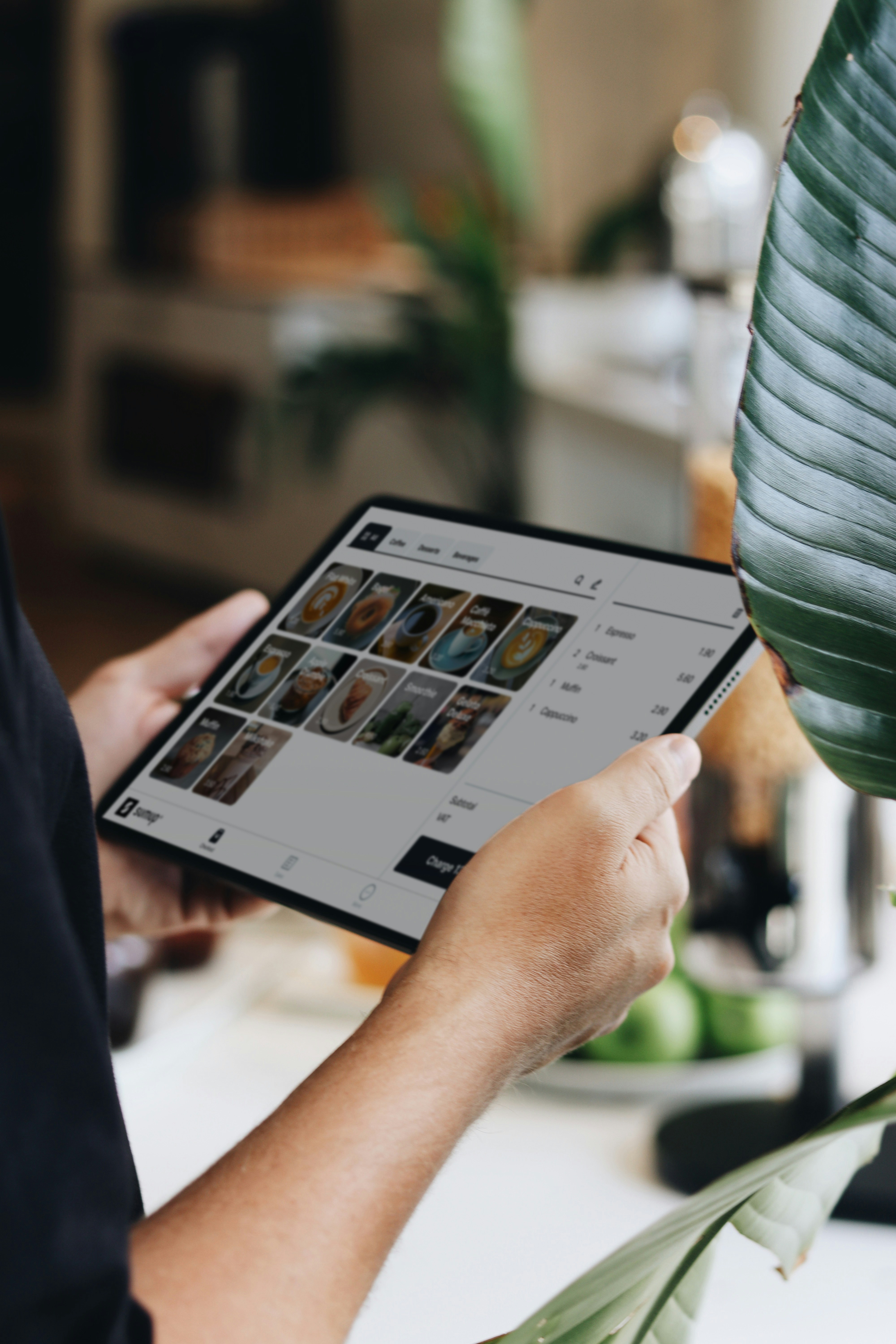 Photo of a hand holding a tablet which is showing and inventory list of products