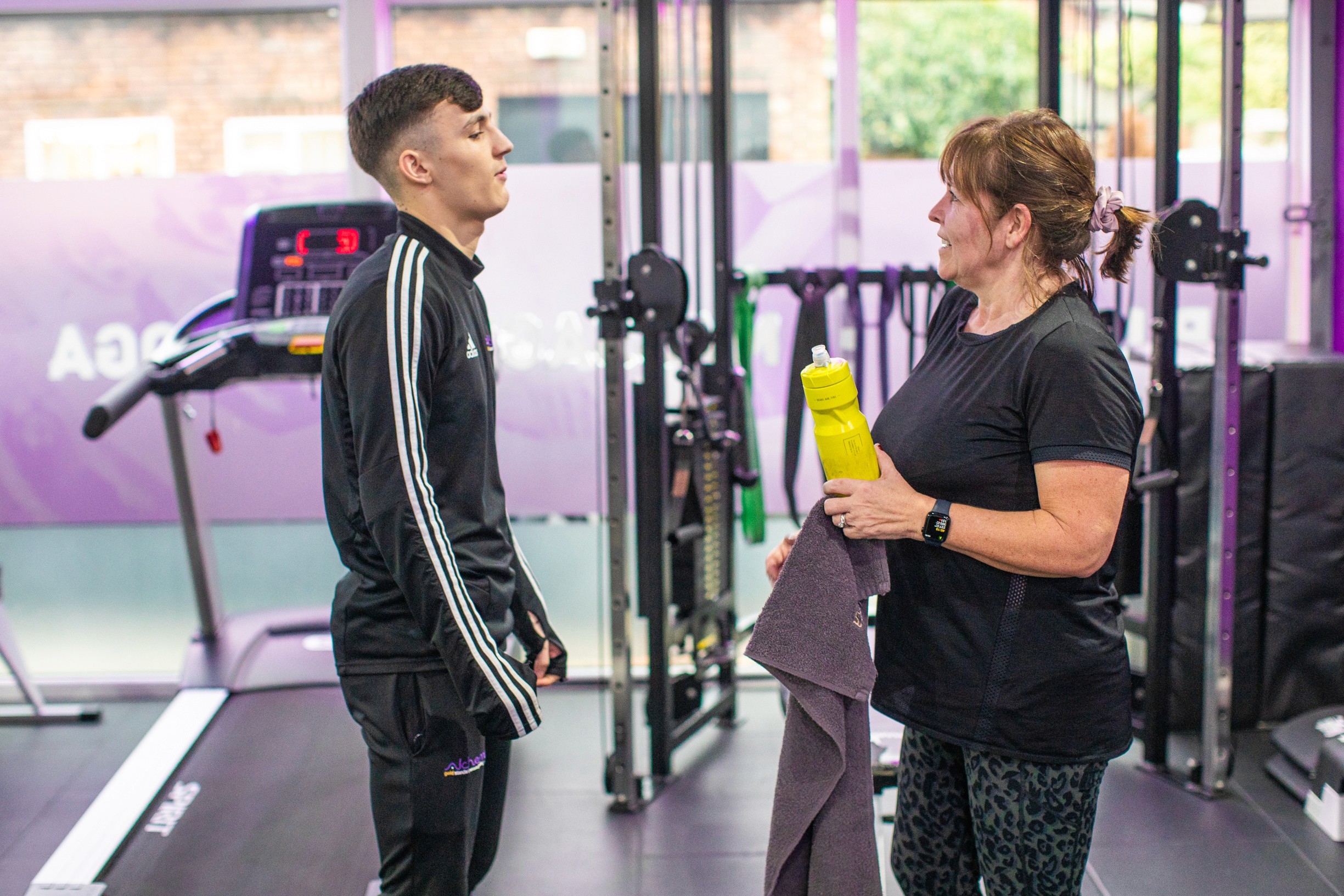A personal trainer discusses nutrition and hydration with a gym member.