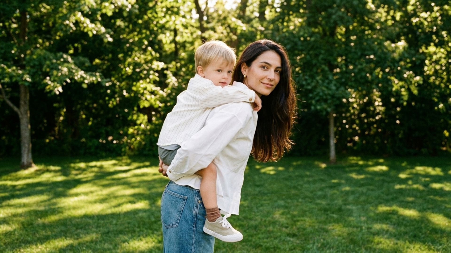 mother carrying her son on her back looking into the camera