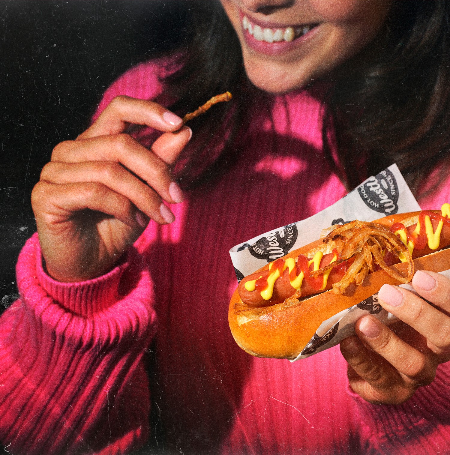 Woman eating hotdog and fries