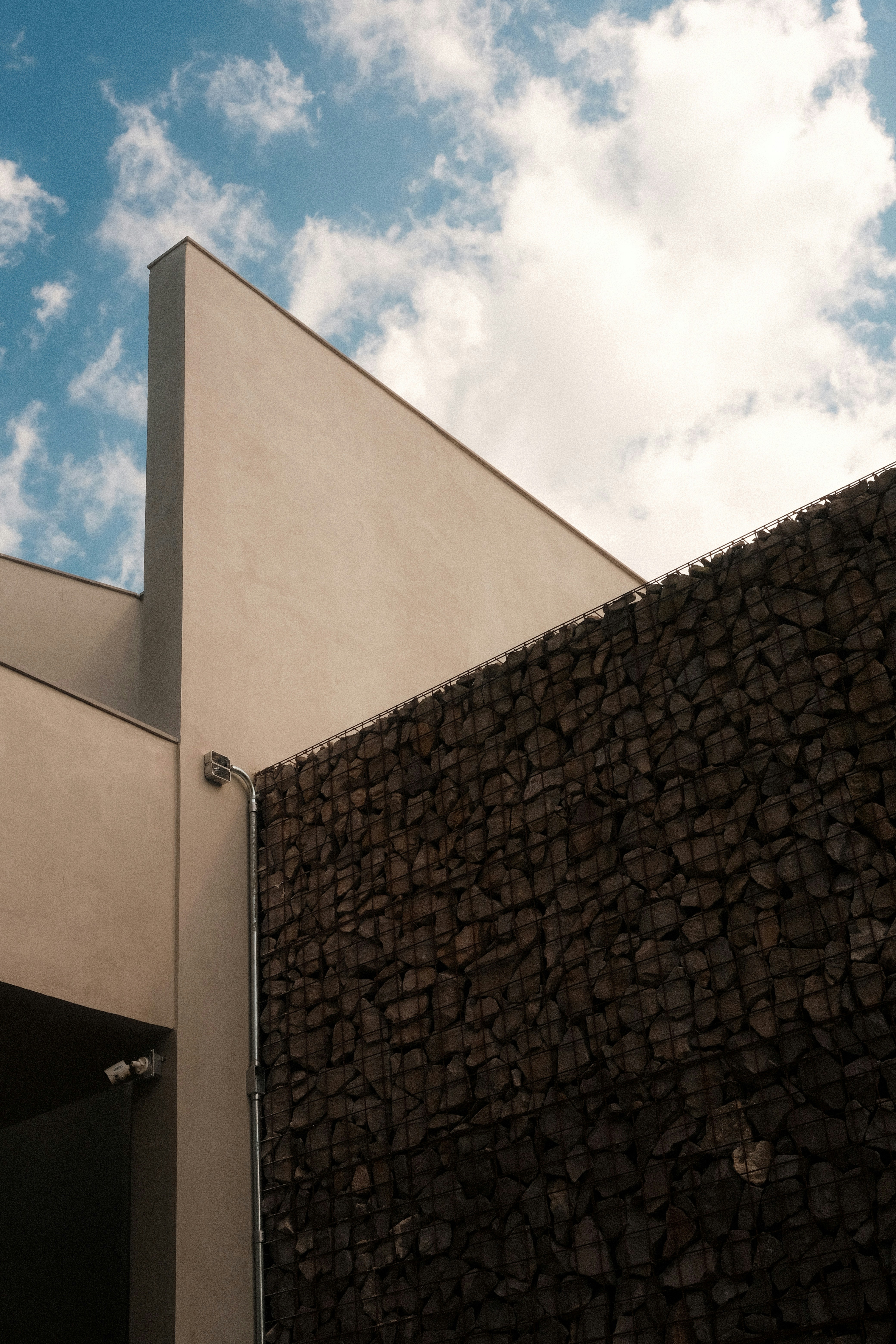 Building with geometric shapes and rock wall.