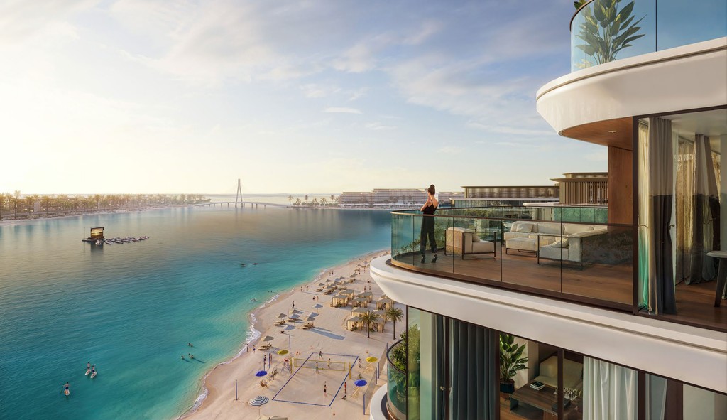 A woman stands on a balcony, gazing at the water view of Delphine Beach.