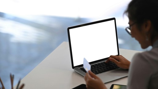 A guest using a credit card and laptop to pay a booking deposit, demonstrating the commitment that reduces no-shows for travel operators.