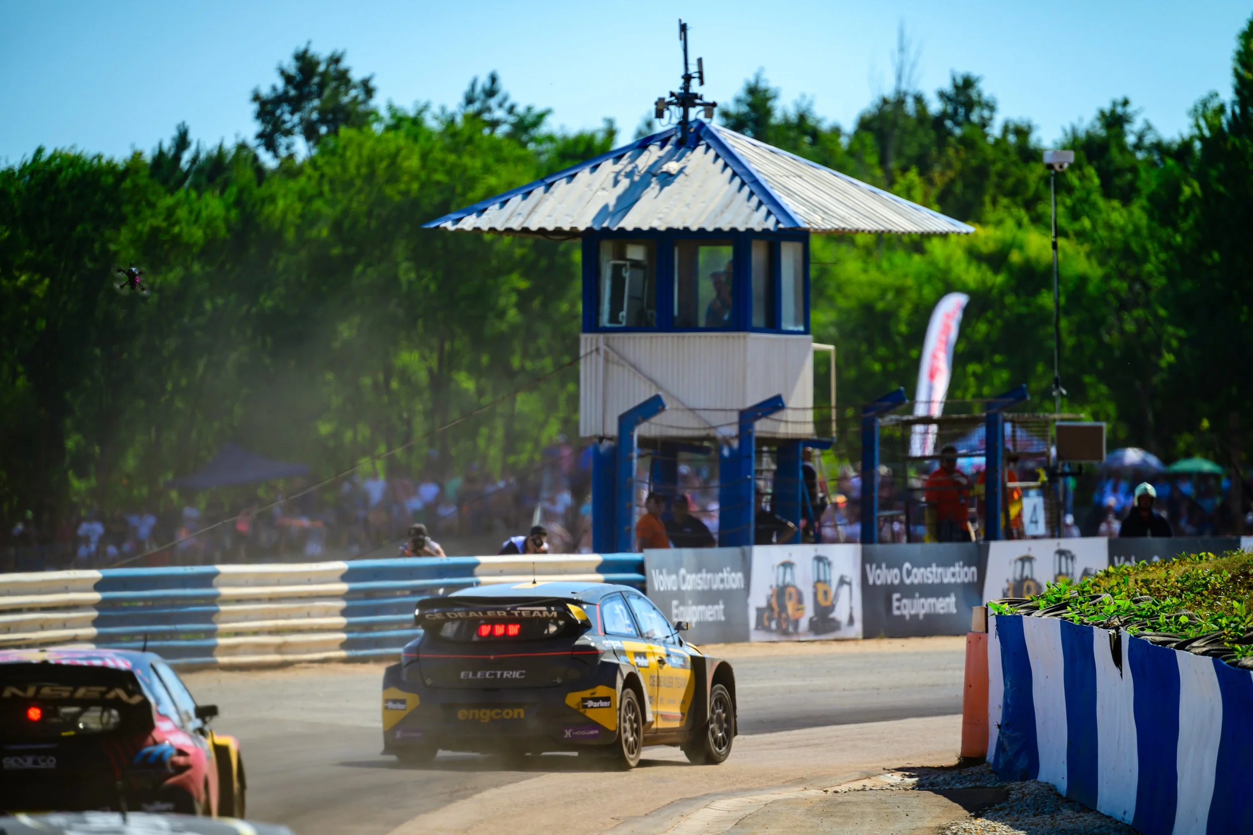 bilar som tävlar på en asfalterad bana inför en stor publik