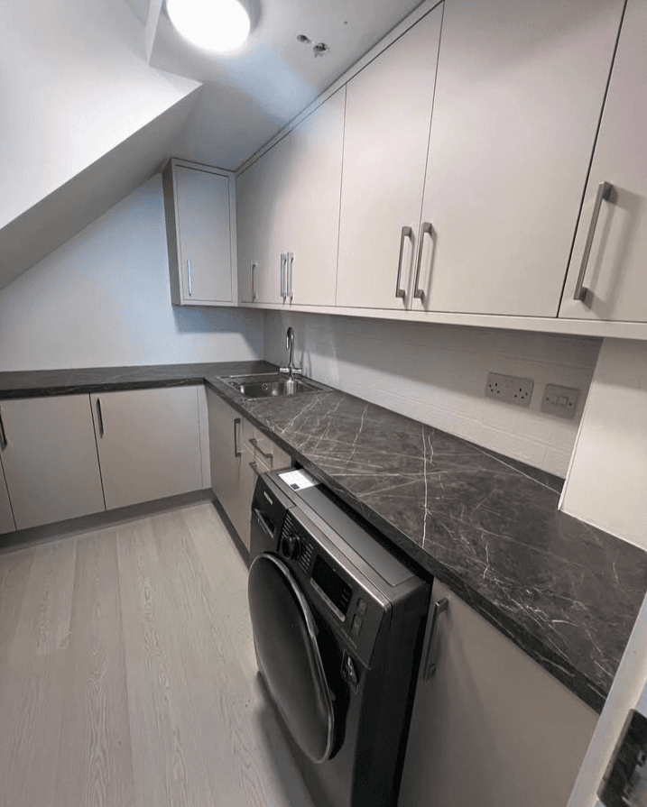 A serene outdoor lounge area with two chairs surrounded by lush greenery and natural light streaming in.