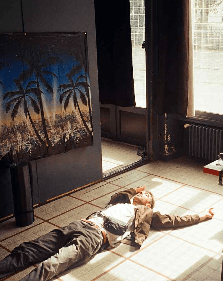 Person, holding a white rose behind his back with one arm on a light blue background