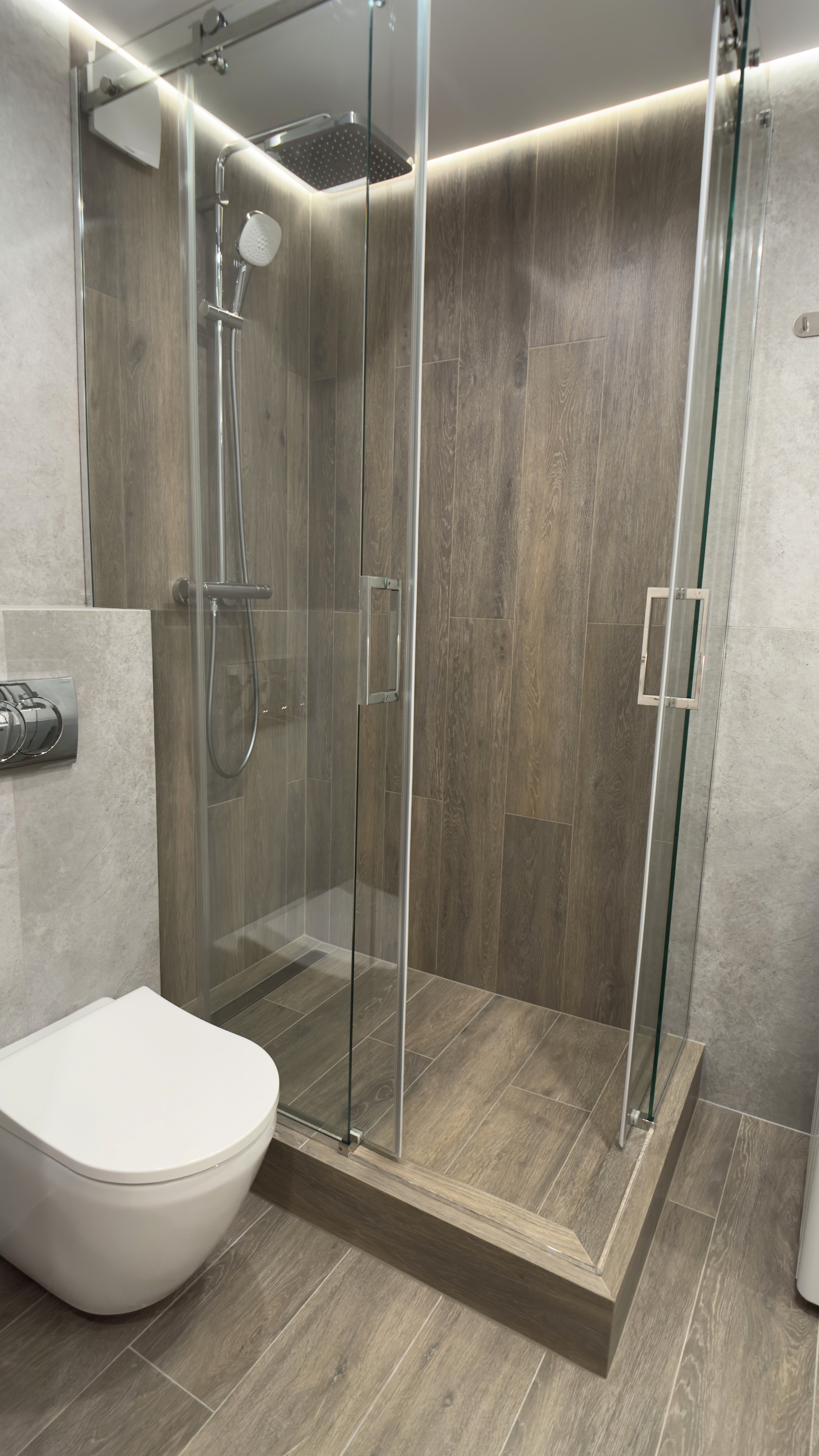 Душова зона з дерев’яною плиткою та скляними дверцятами