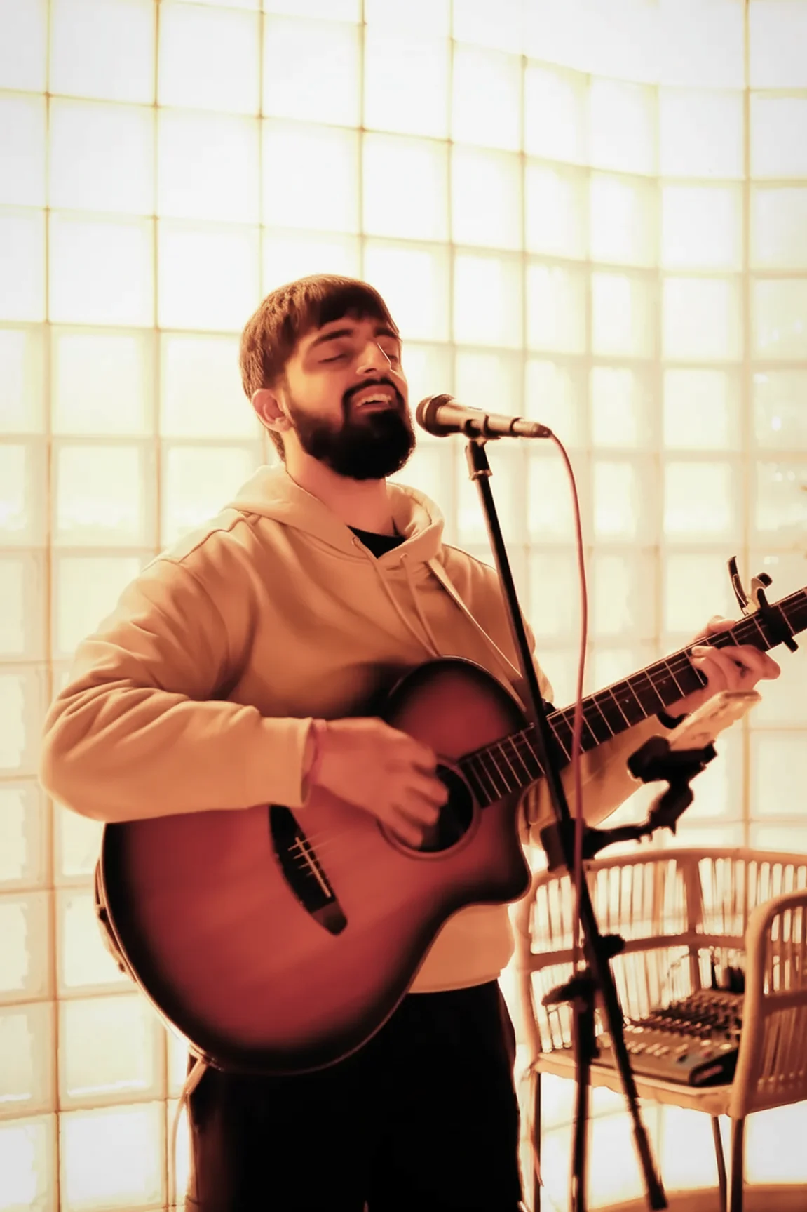 Singer playing guitar with his eyes closed