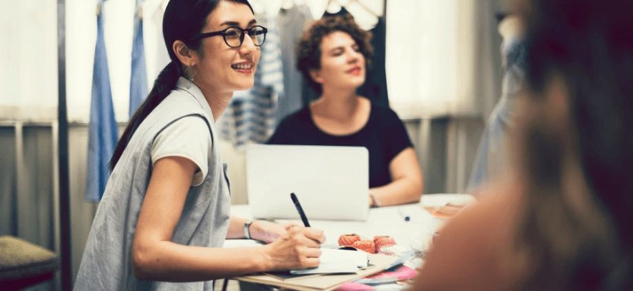 three women in a business meeting around a table