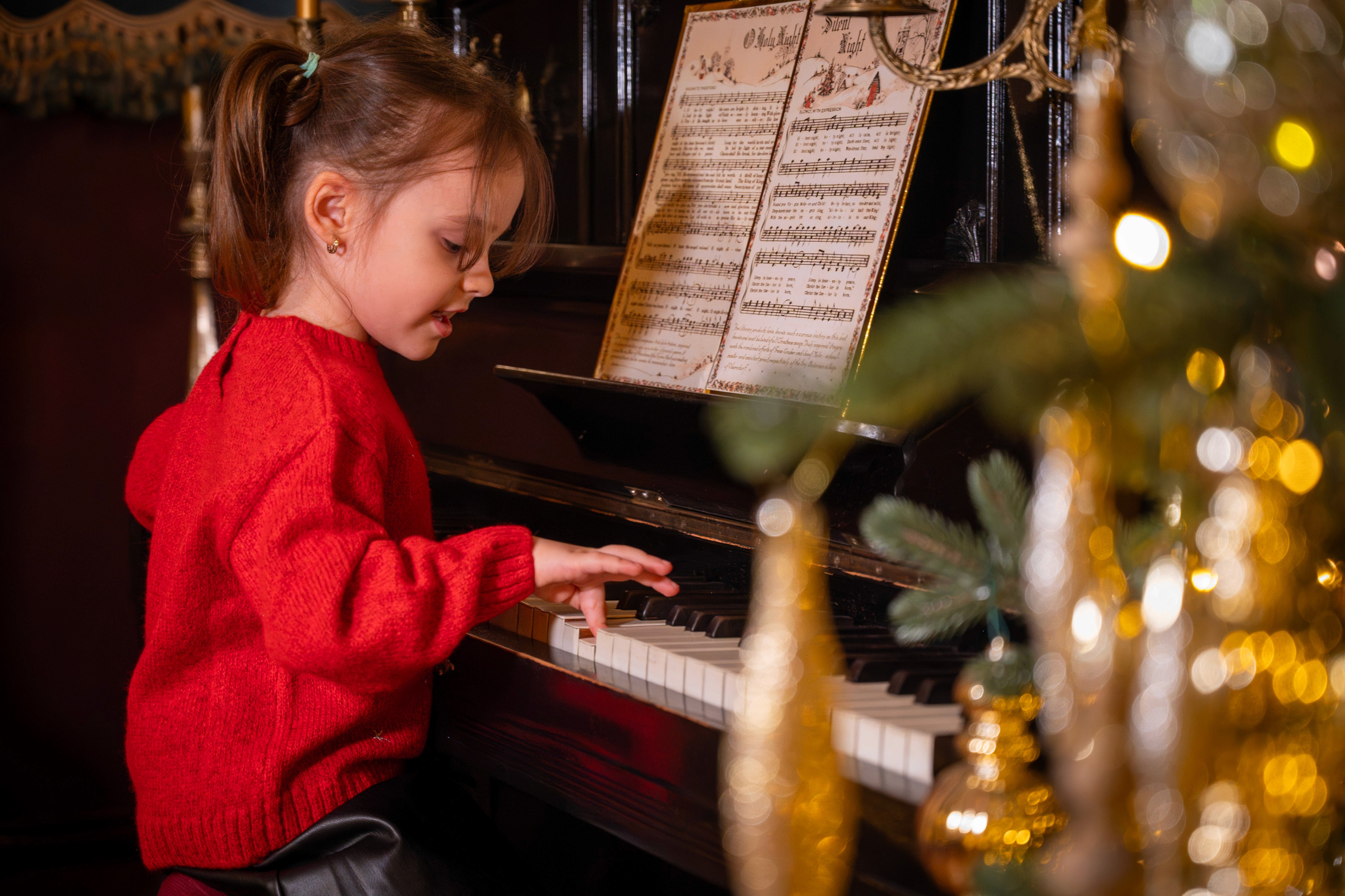 Fotografii de Crăciun cu copil cântând la pian, cadru intim și cald