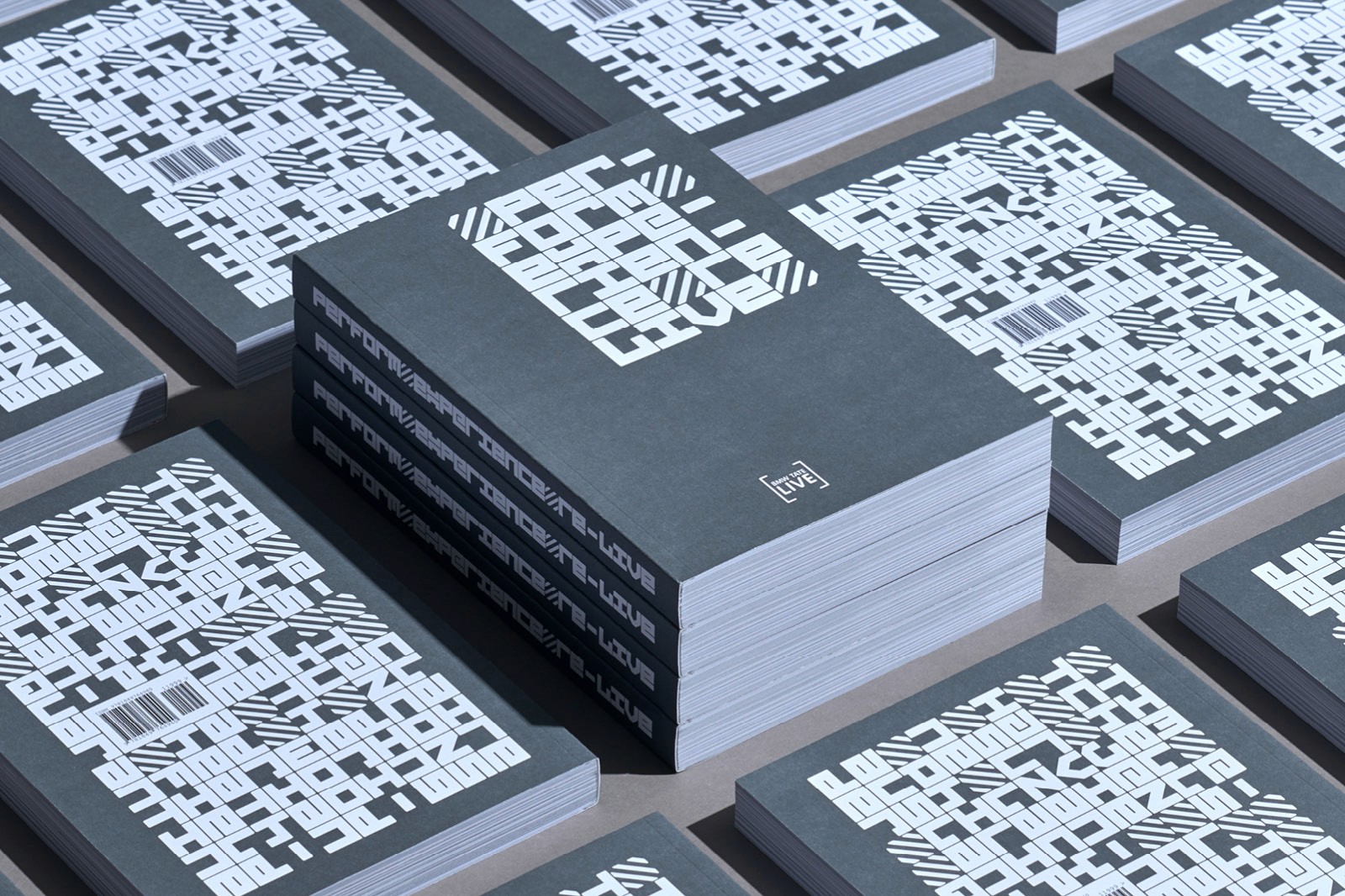 Stacks of books with dark grey covers featuring intricate white geometric patterns are arranged neatly on a flat surface.