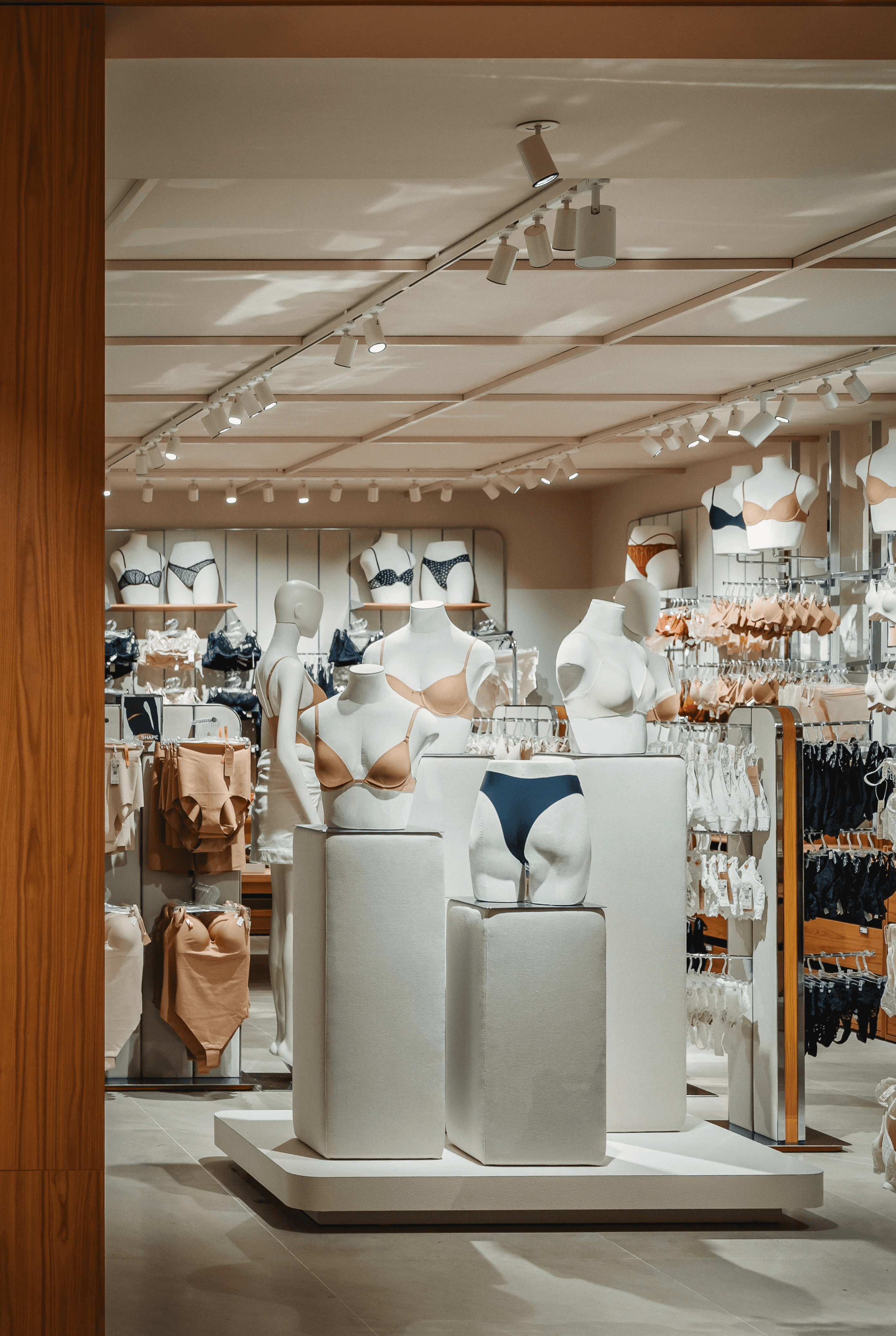 Mannequins bustes présentant culottes et soutiens-gorge, présentoirs modulables, éclairage directionnel au plafond