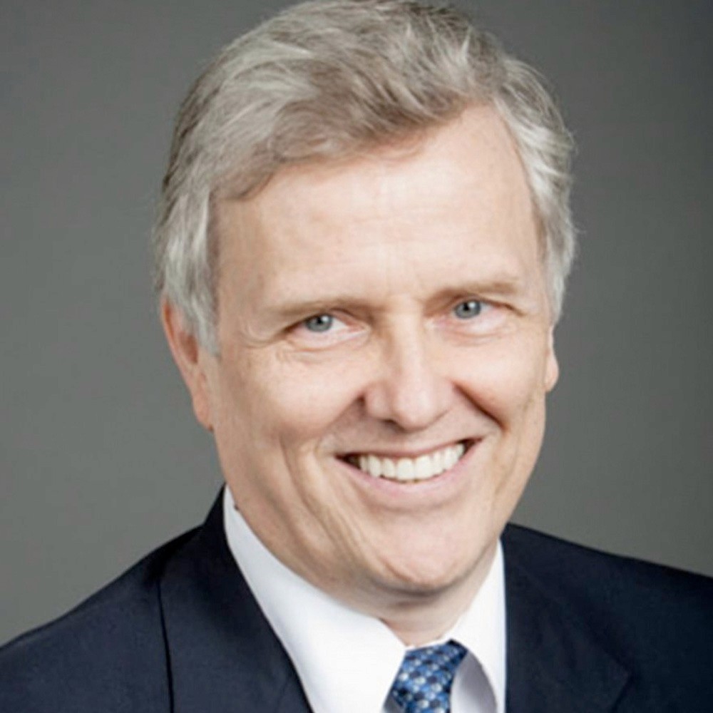 A man standing in front of a window smiling