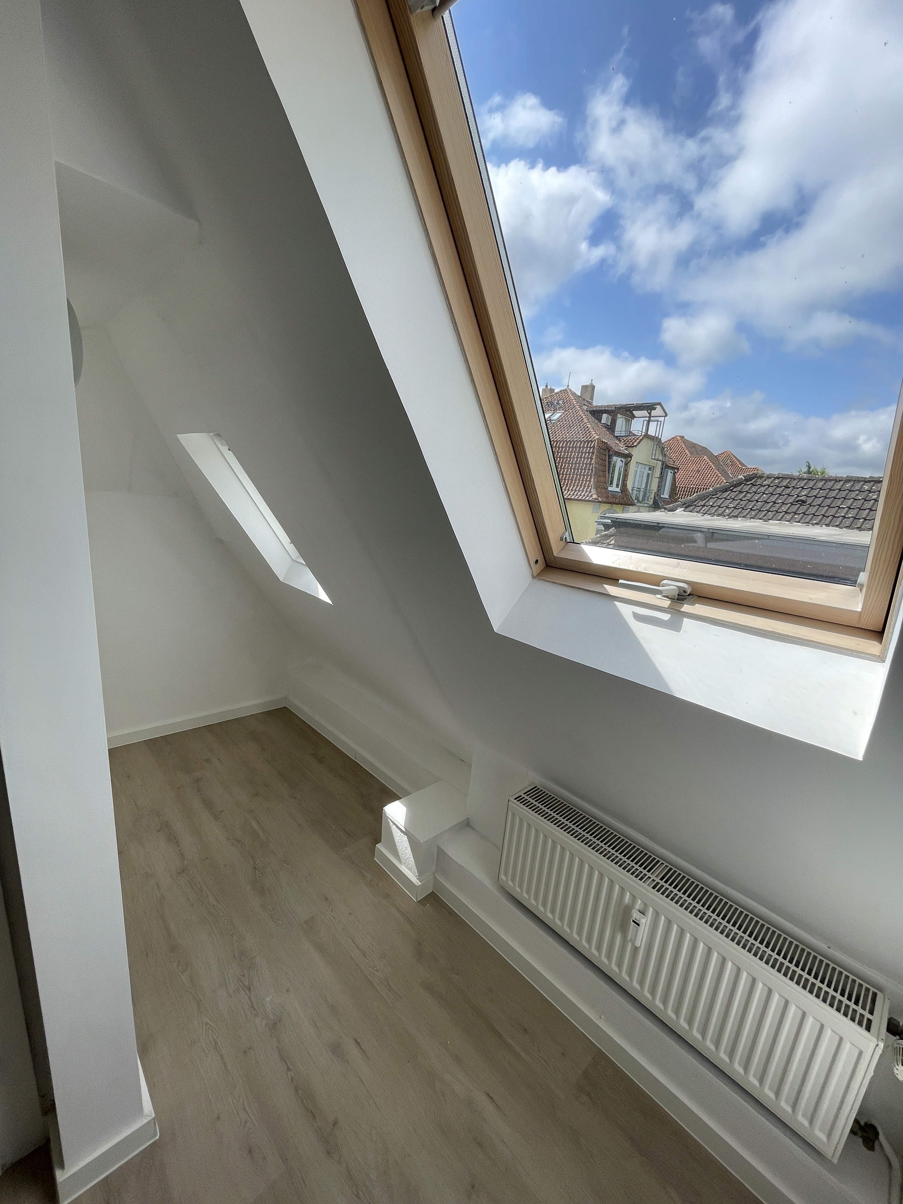 Renovierte Dachschräge mit neuem Fenster im sanierten Wohnraum der Wenkenstraße