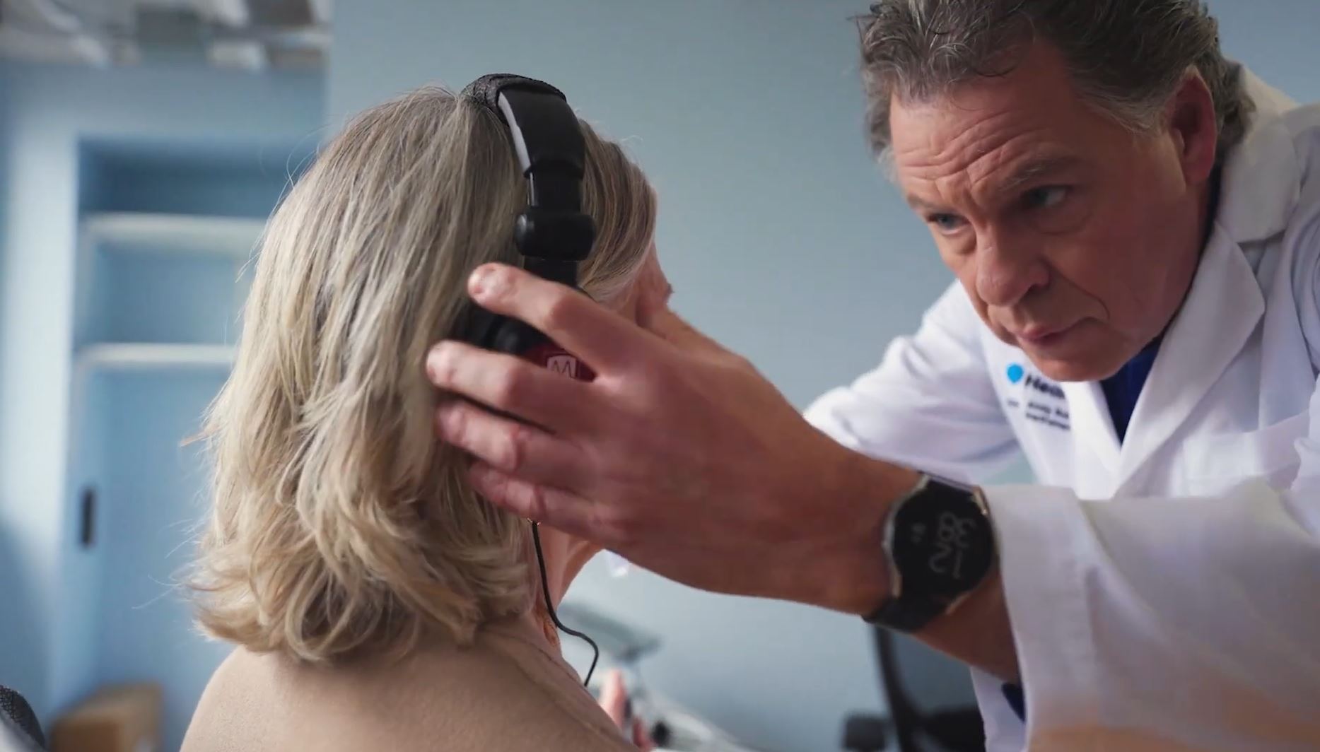 Split-screen graphic with a green solid background on the left and a modern building covered in lush greenery on the right. In the center, a minimalist white architectural logo resembling a pitched roof structure connects both sides.