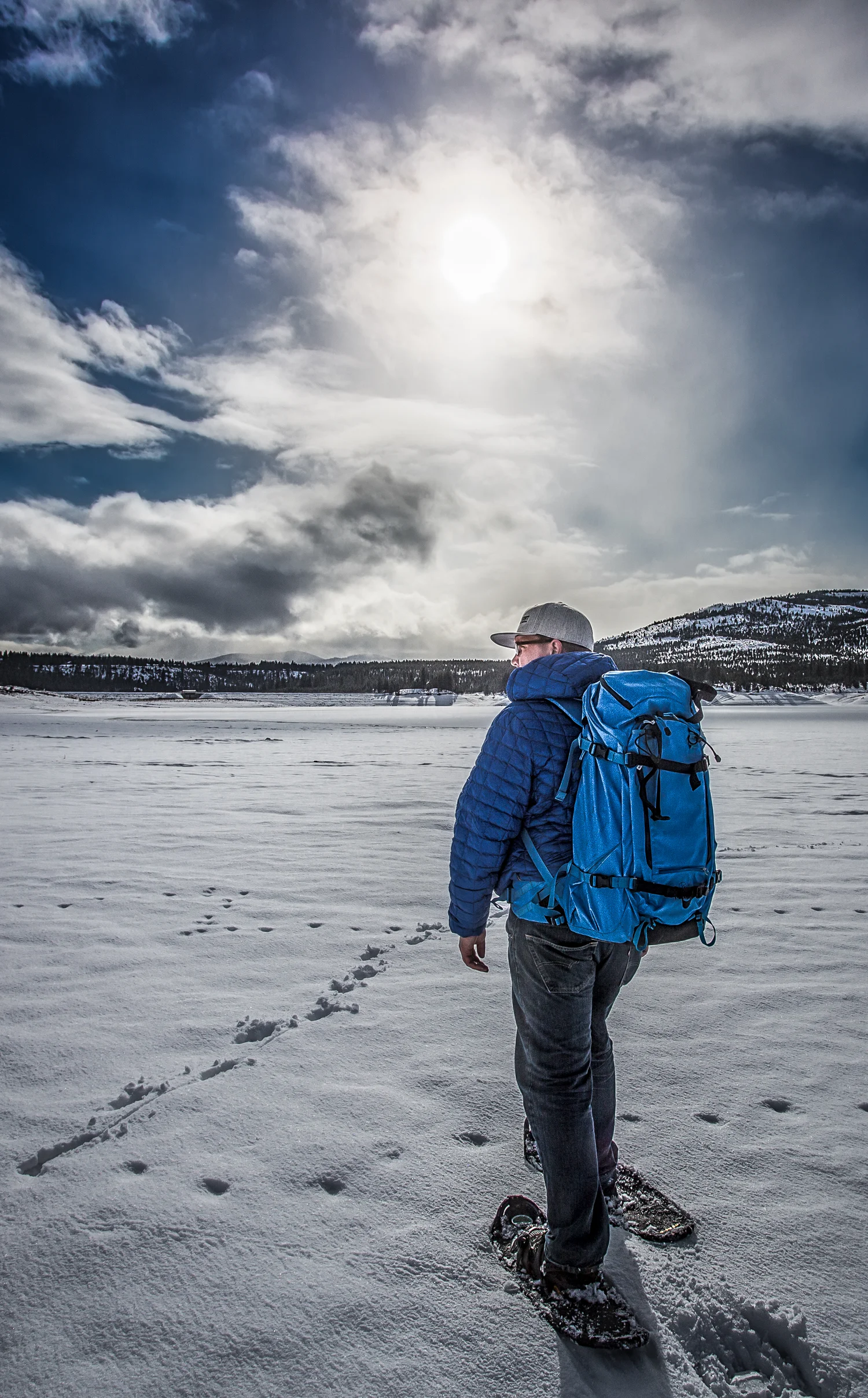 Tom Ackerman snowshoeing across a frozen lake with camera gear, Sierra Nevada