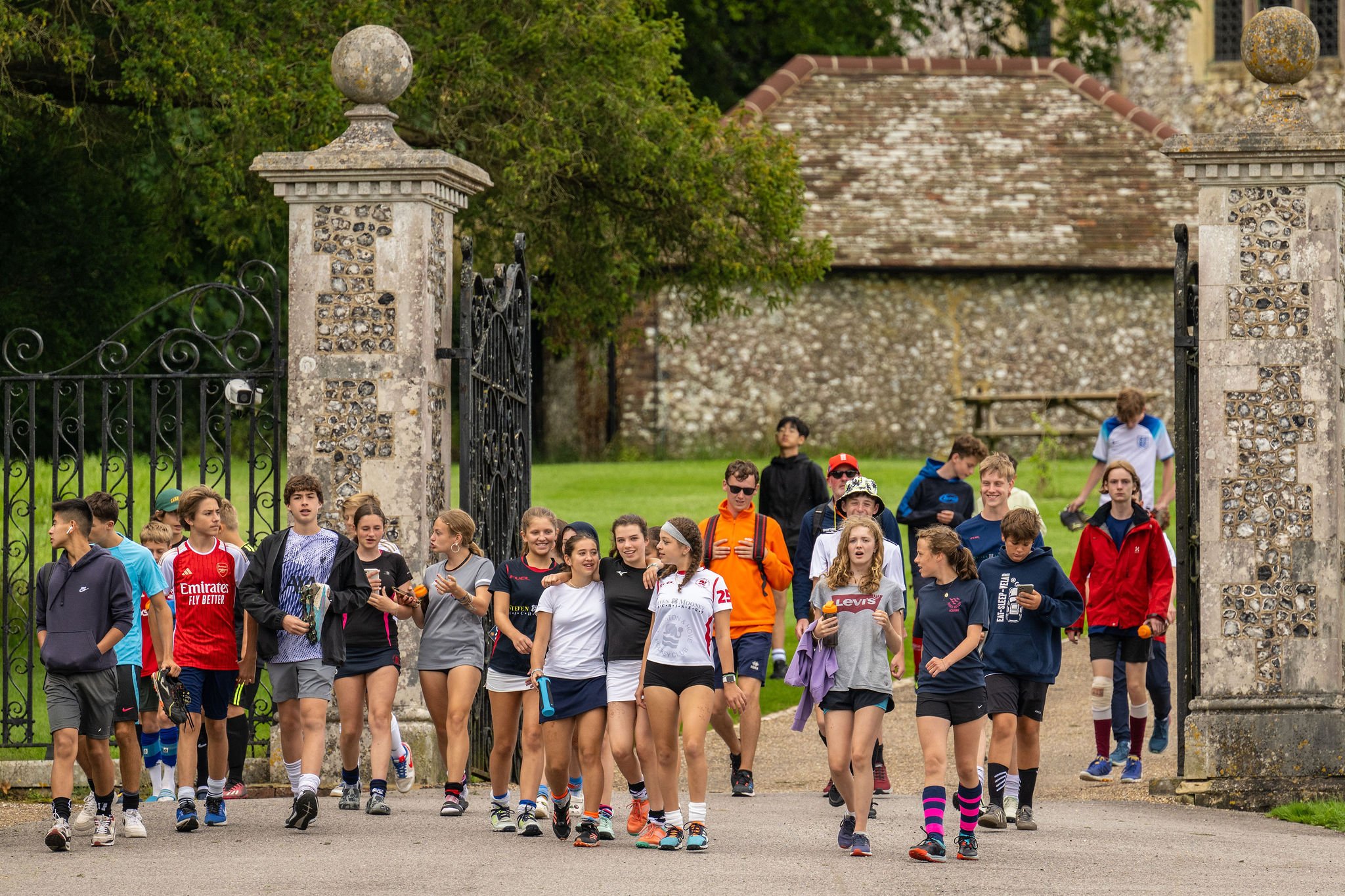 A group of students and staff walking to their sports while chatting.
