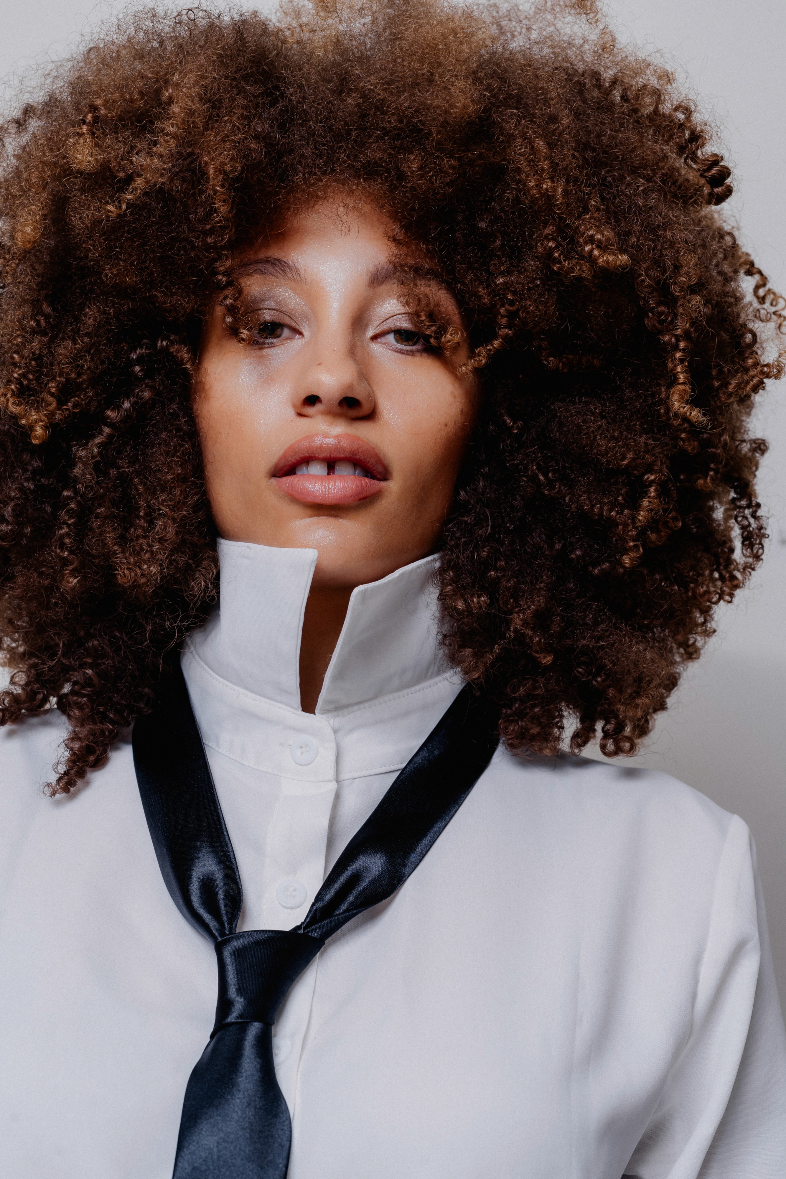 woman looking sideways leaning on white wall