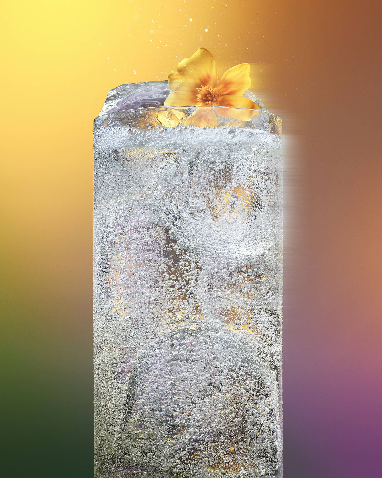 A tall, bubbly cocktail with ice structures and a bright yellow flower on top, set against a colorful gradient background.