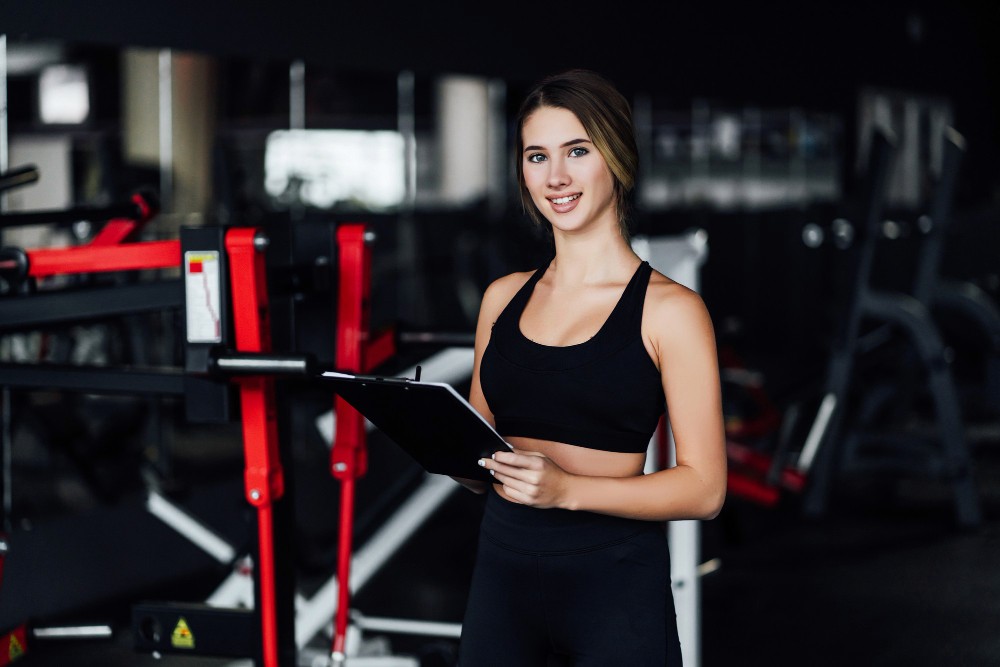 Fitness trainer holding a clipboard in a gym