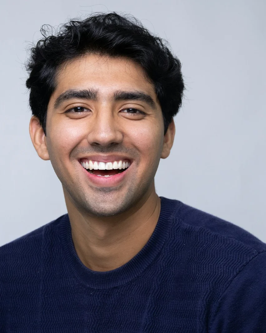 Kiran Mehta smiling in a navy jumper