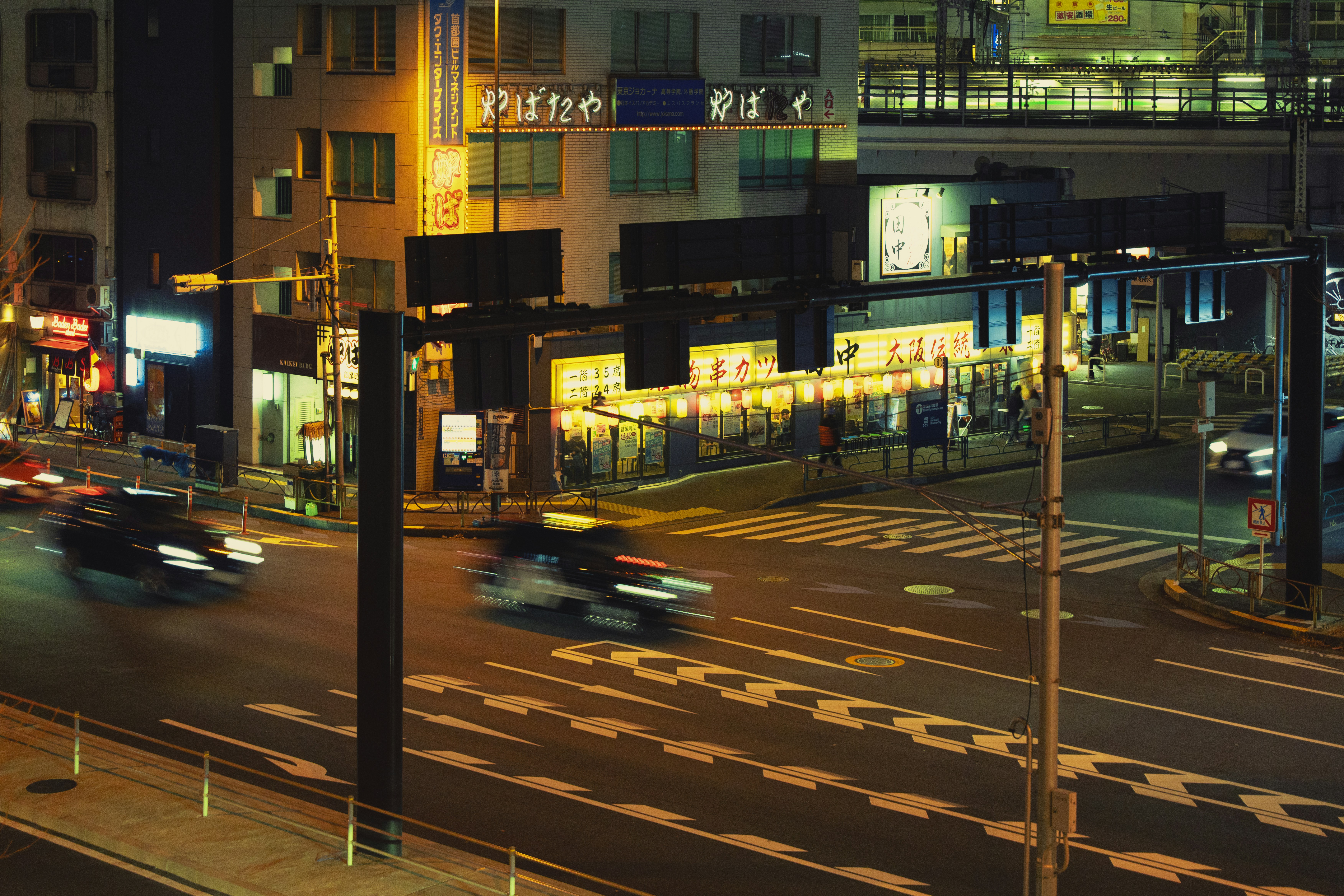 Cars driving on a busy city street at night.