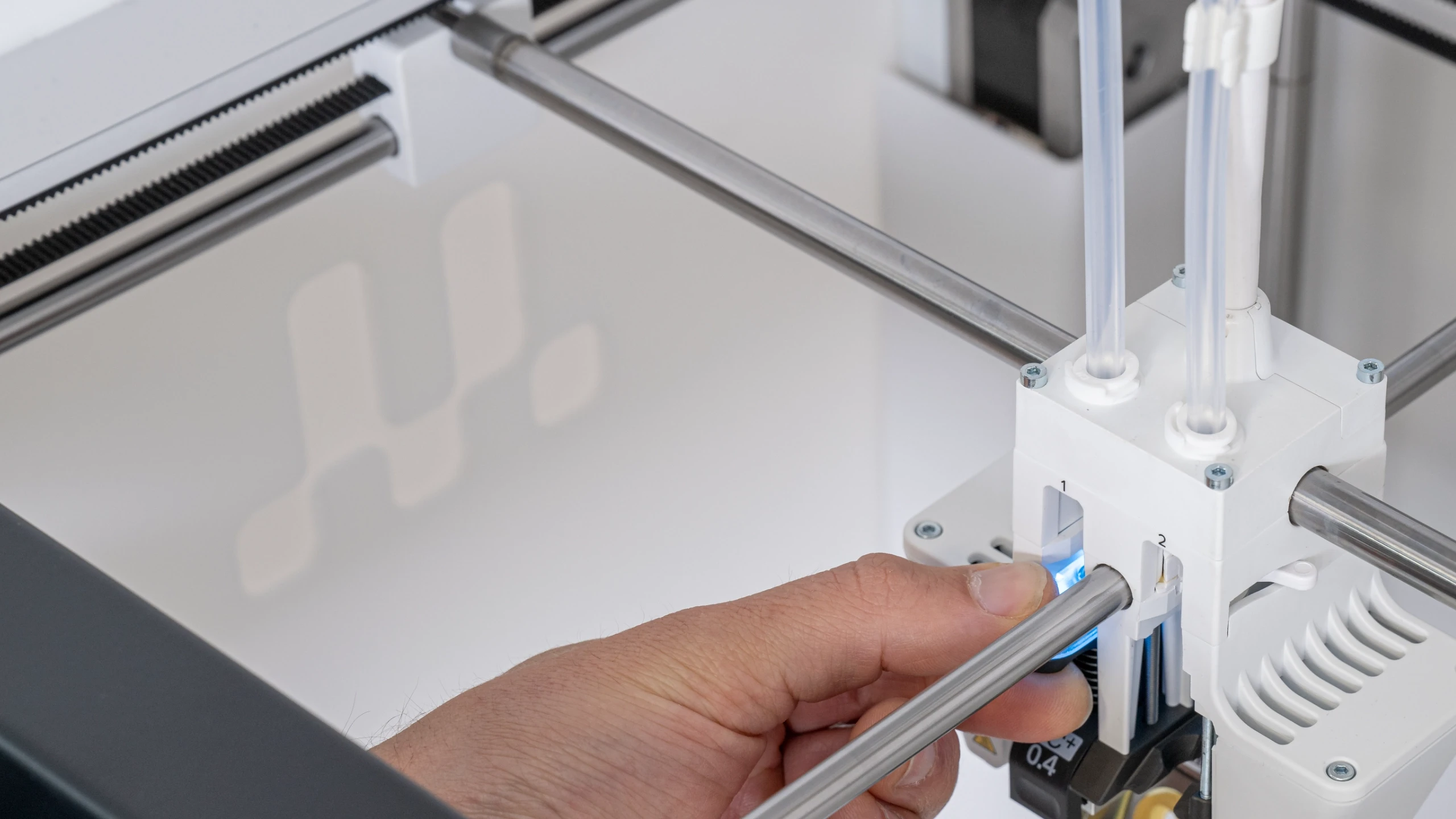Modern home office setup with a monitor, ergonomic chair, keyboard, and indoor plants near a window with blinds.