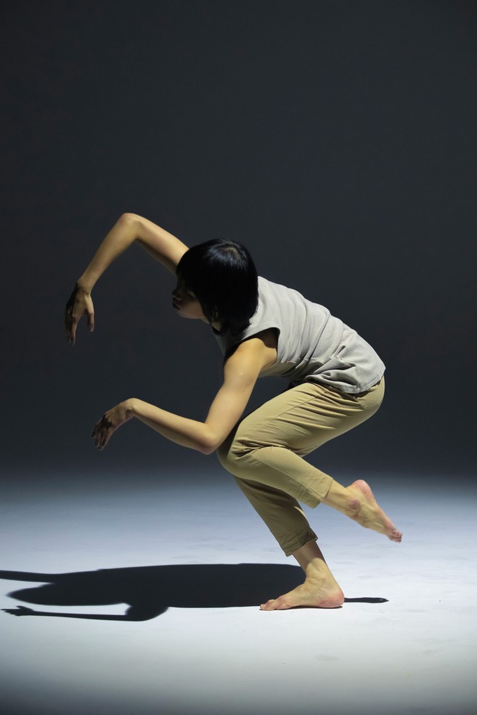 a woman is doing a dance move in the dark