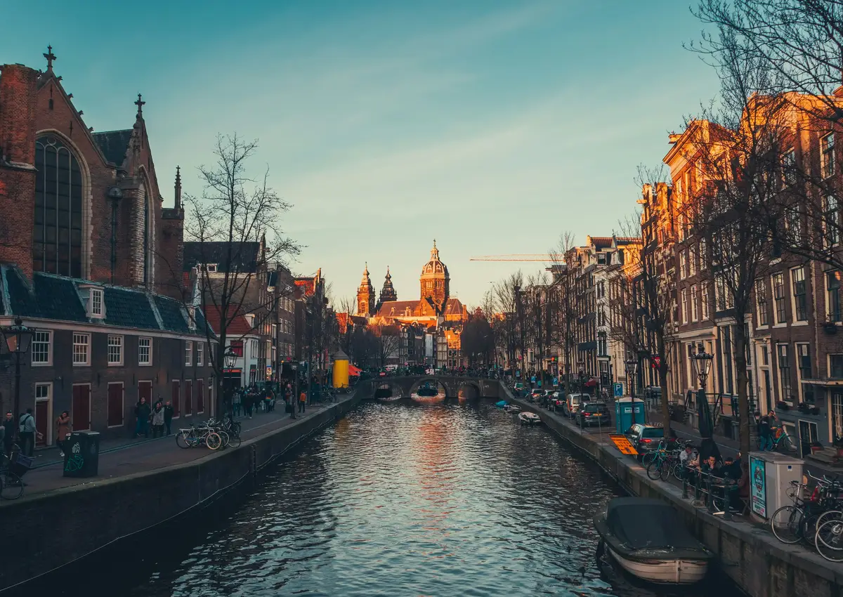 Une vue de canal dans une ville européenne avec des bâtiments historiques et des gens le long de l'eau