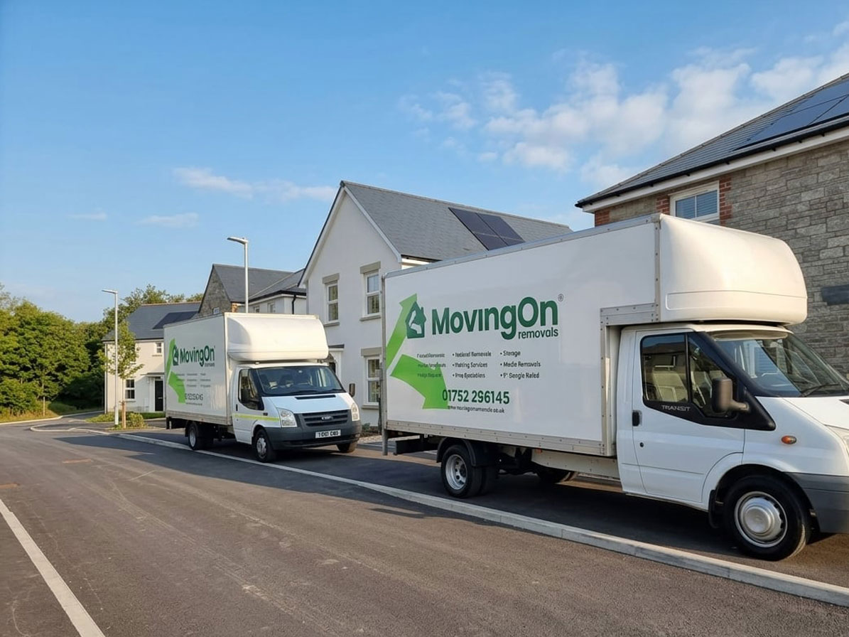 Two Moving On Removals transit vans parked outside a new build housing development during a home relocation from Plymouth to Saltash Cornwall.