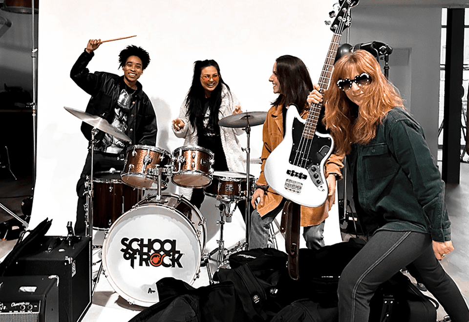 Seven people stand on a rooftop at sunset, smiling with drinks in hand against a cityscape—capturing the vibrant, collaborative environment that defines TBC.