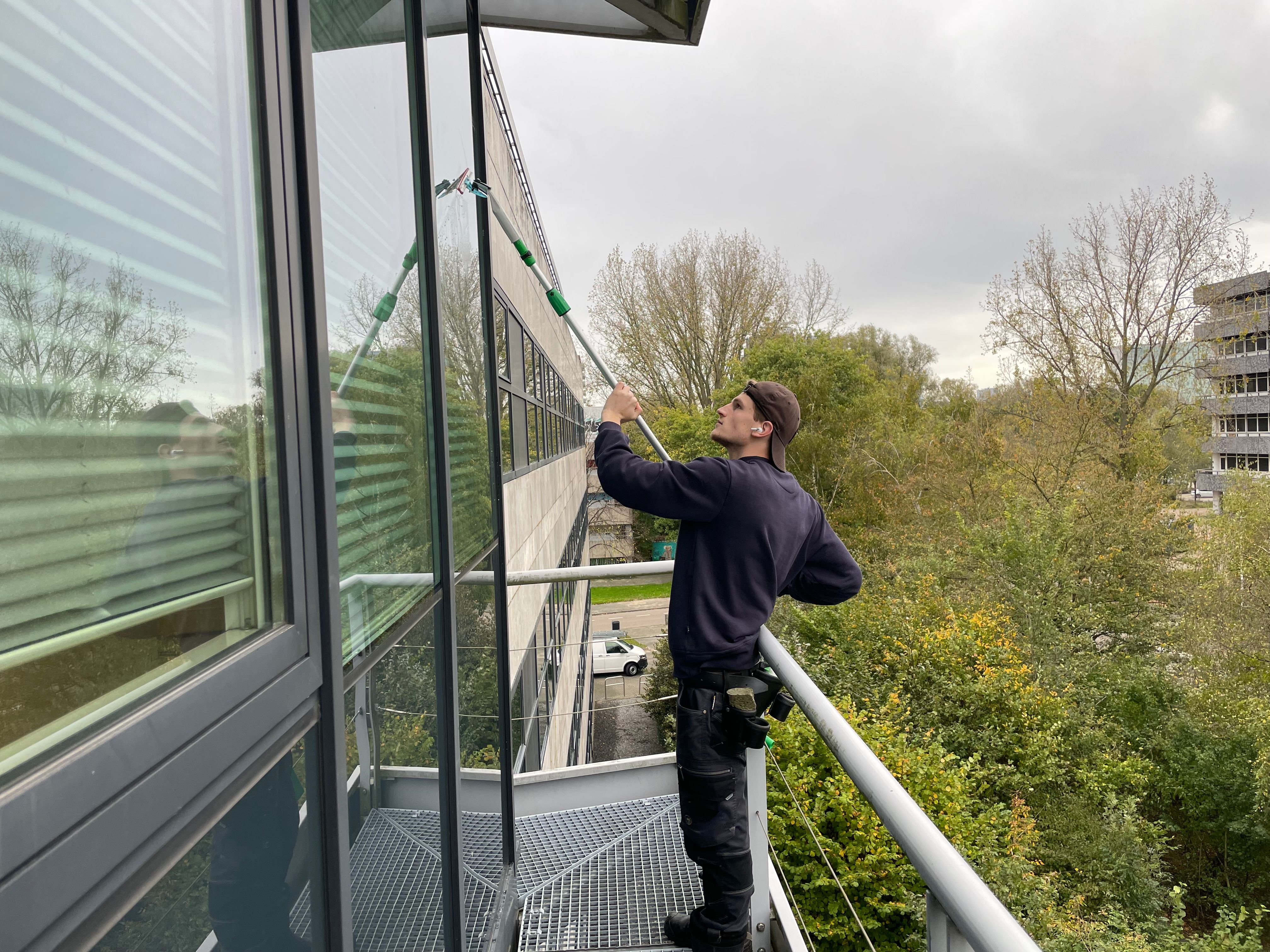 A diverse team collaborates around a table, analyzing documents and charts in a professional setting with a light green background.
