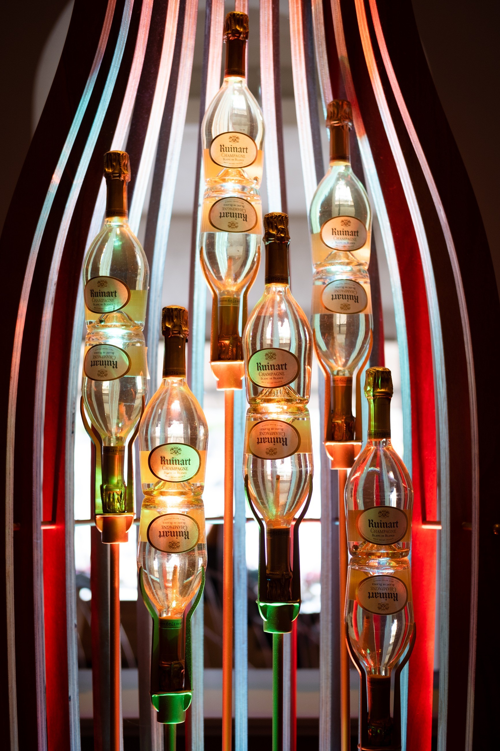 Champagne bottles displayed within a sculptural frame