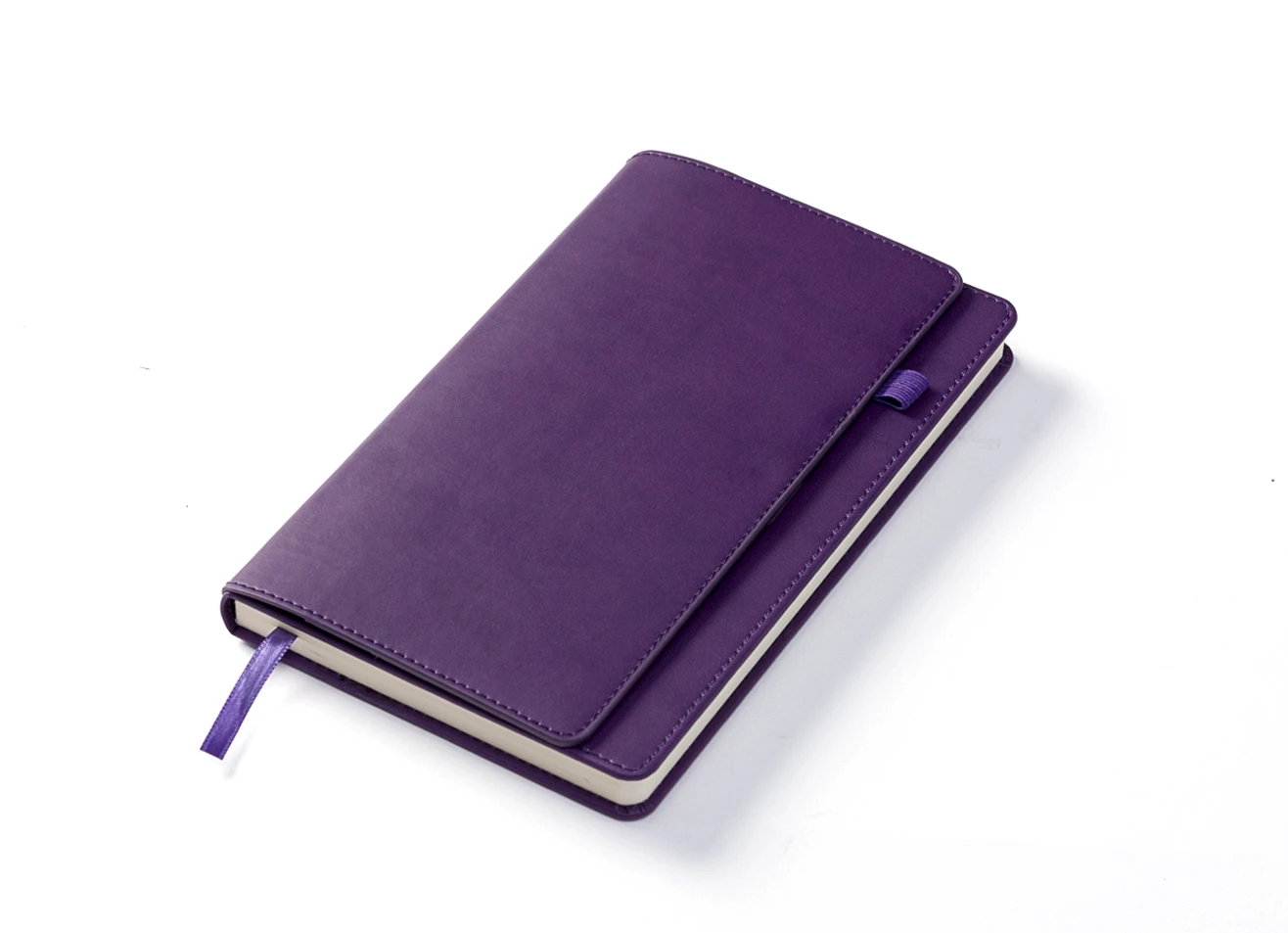 Angled view of closed purple notebook with ribbon.