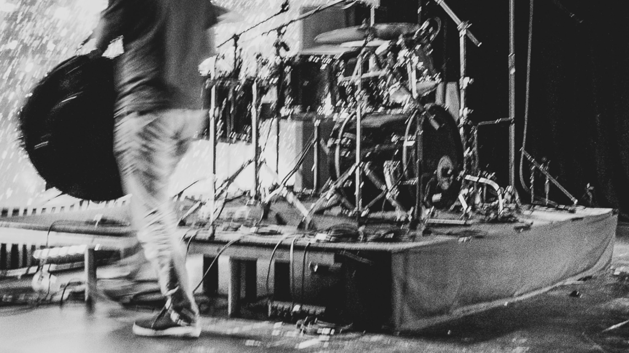Person packing up a drum kit.