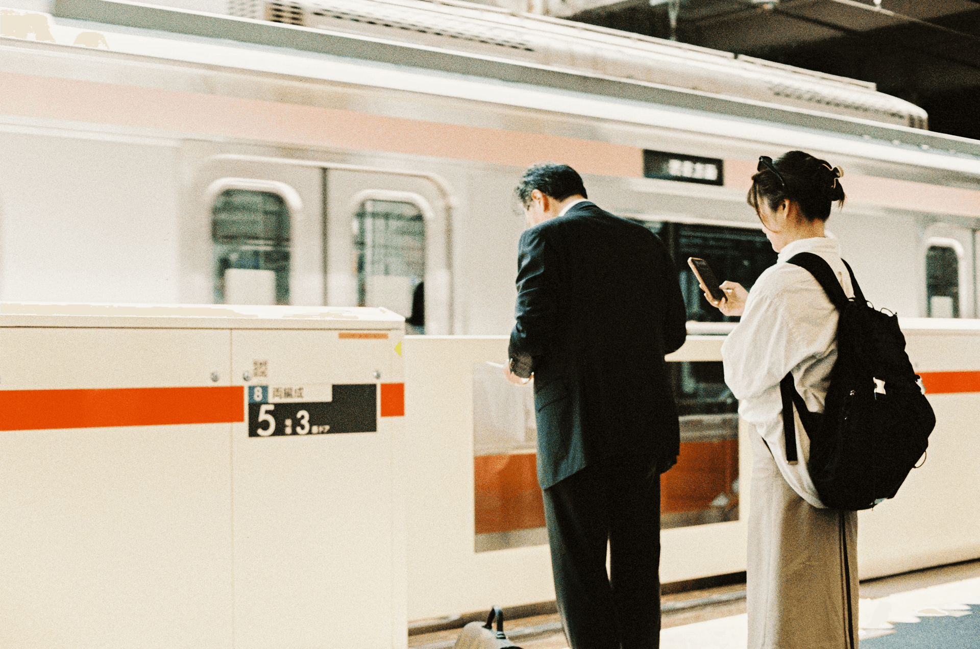 A businessman and a woman using her smartphone stand on a train platform, serving as a conceptual graphic for a guide comparing the best Skylead alternatives.