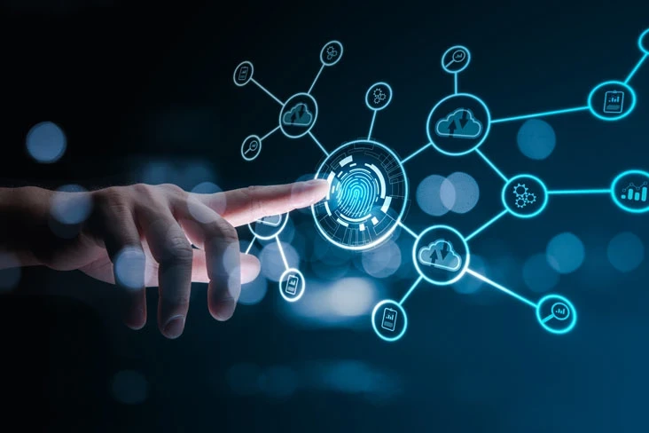 A person walks in front of large stone arches with dark doors, flanked by tall columns, in a historic building.