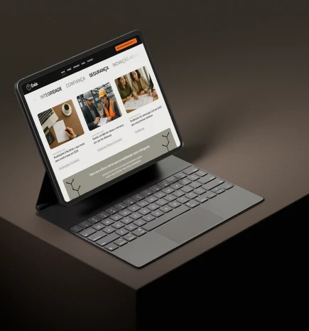 Site da Éxis Contabilidade projetado em um tablet que está sob uma mesa.