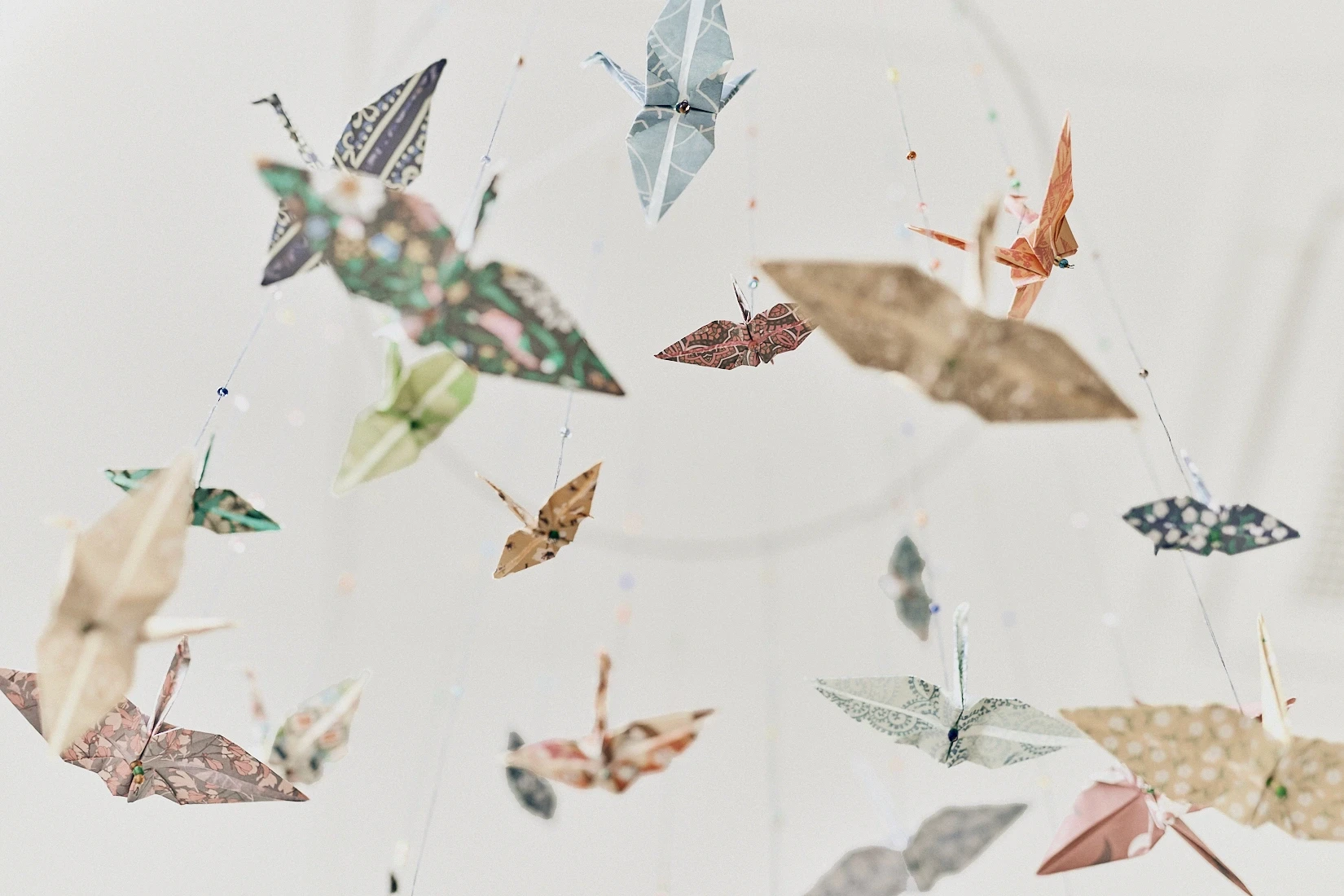 Dekorative Origami-Kraniche schaffen eine beruhigende Atmosphäre – ganzheitliche Betreuung von Schwangeren in der Praxis für Pränataldiagnostik und Feindiagnostik.