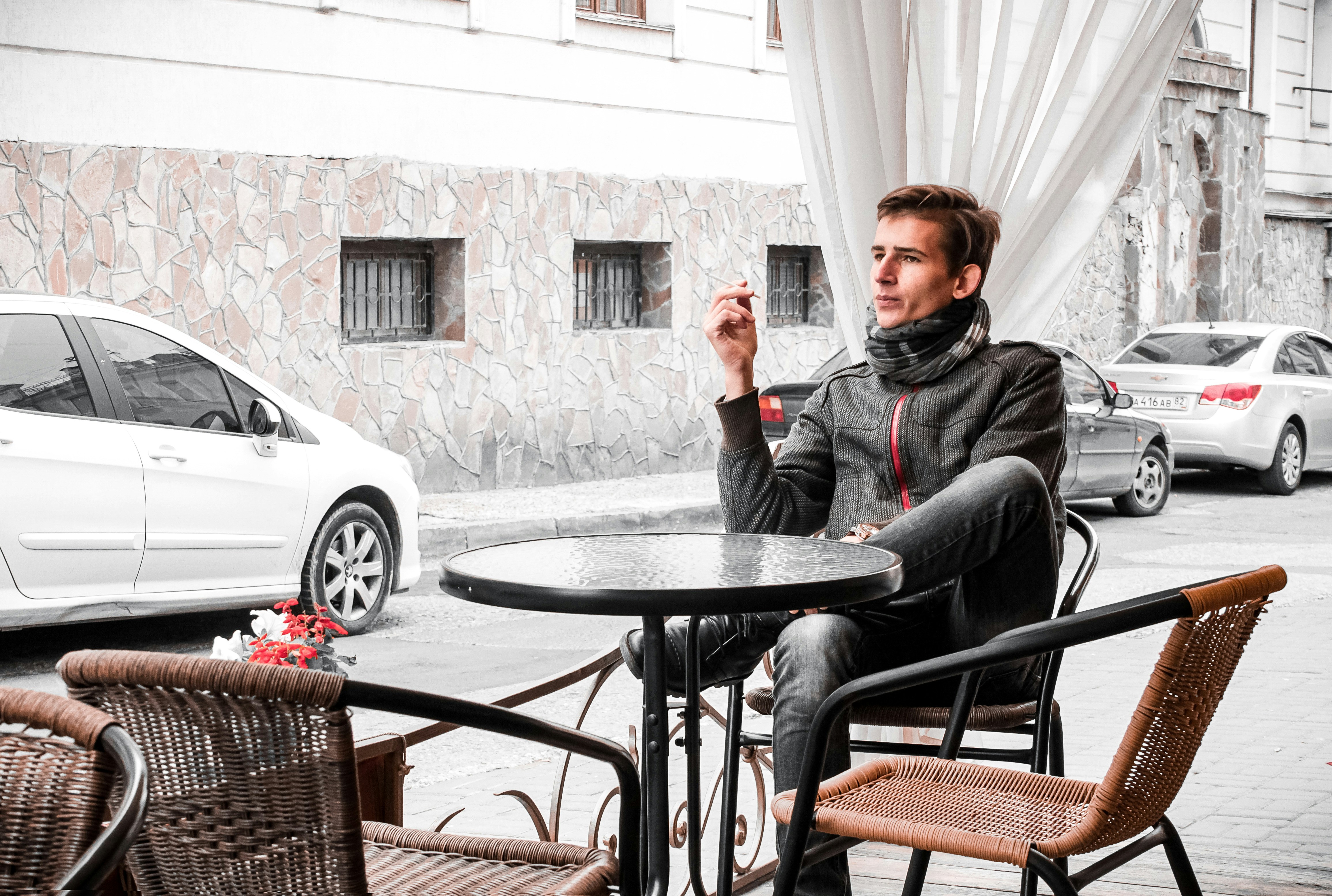 man in black jacket sitting on chair near table