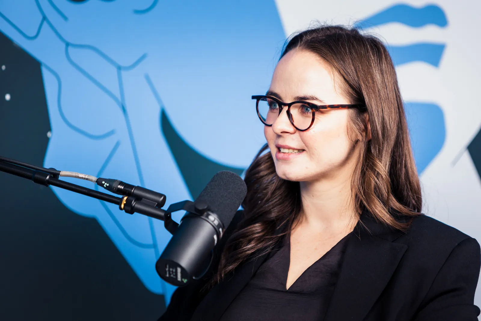 The Index podcast host speaking into a Shure SM7B microphone in the mobile podcast studio at BIKOSS 2026