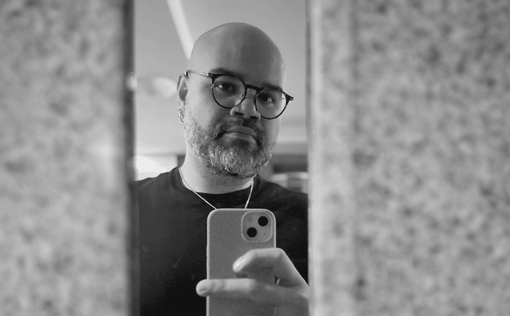 Peace Badejo, wearing sunglasses, looking to the left.