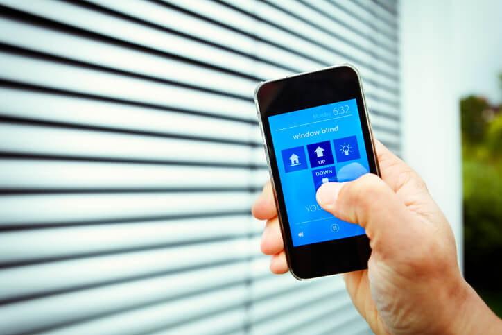 person using phone app to control smart blinds