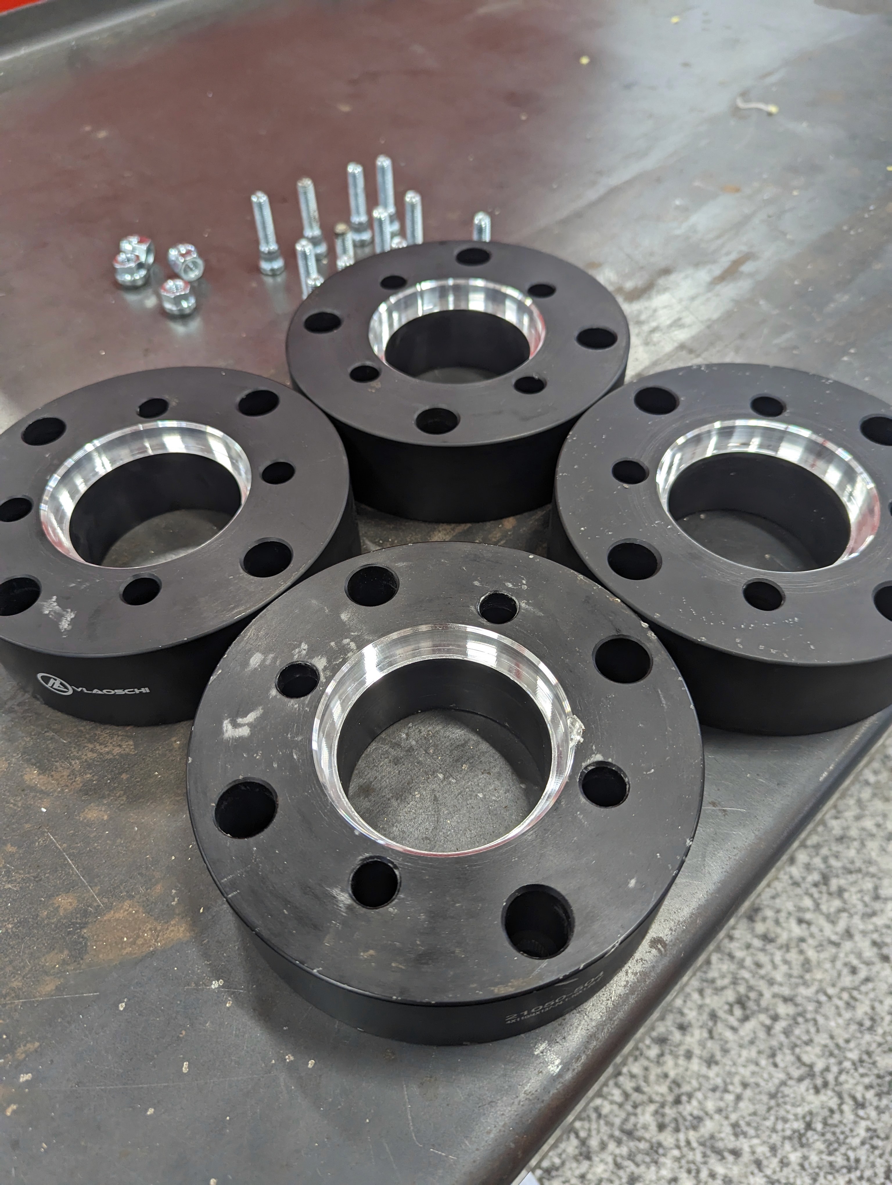 Four aluminum wheel spacers with the center machined out to a larger size to fit a larger hub flange