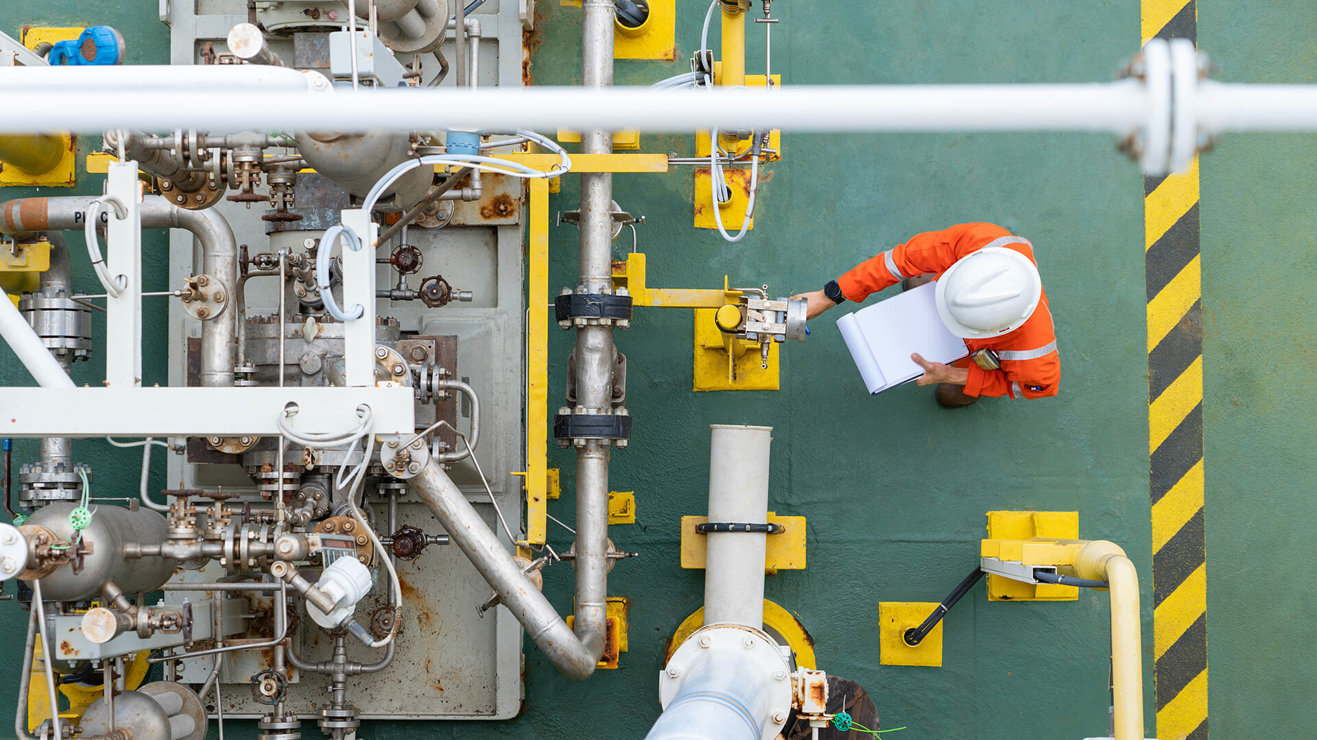 Vogelperspektive eines Technikers von Franke + Pahl bei der systematischen Inspektion einer komplexen Industrieanlage mit Prüfprotokoll zur Sicherung der Anlagenverfügbarkeit