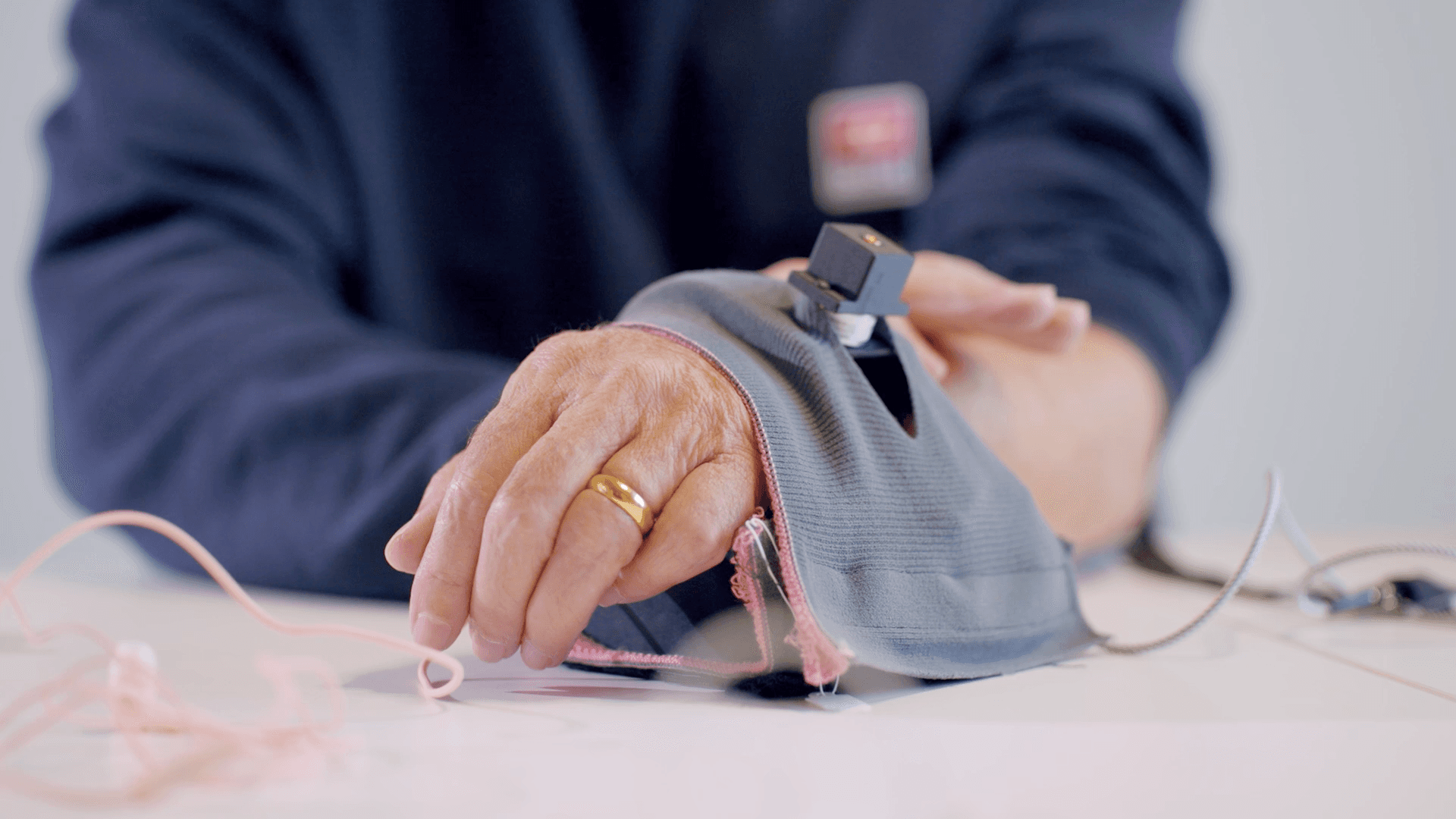 Hand of an eldely man wearing a wearable device, wrapper aroud the wrist.