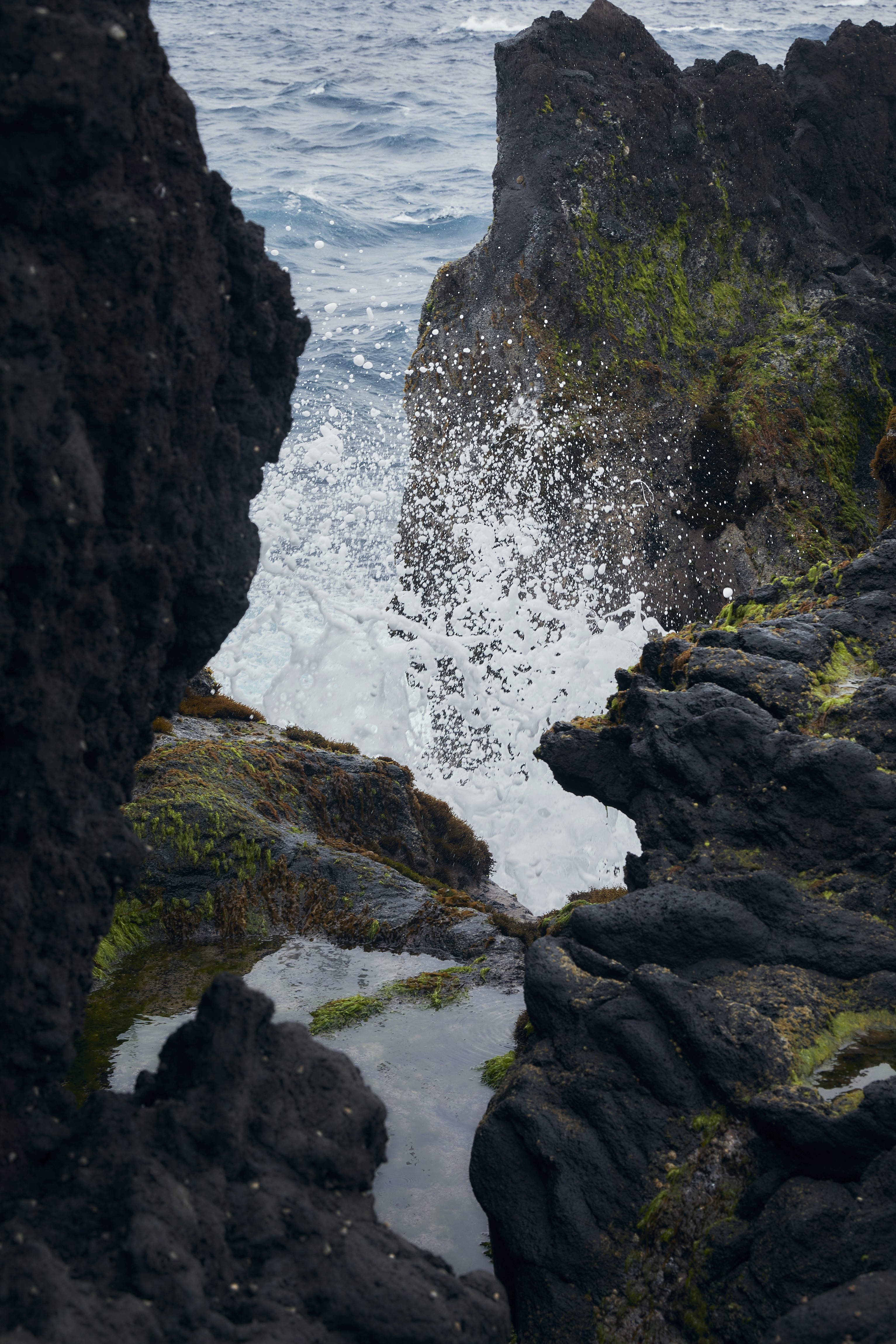 Volcanic shoreline of Hachijojima with waves hitting the black rocks.