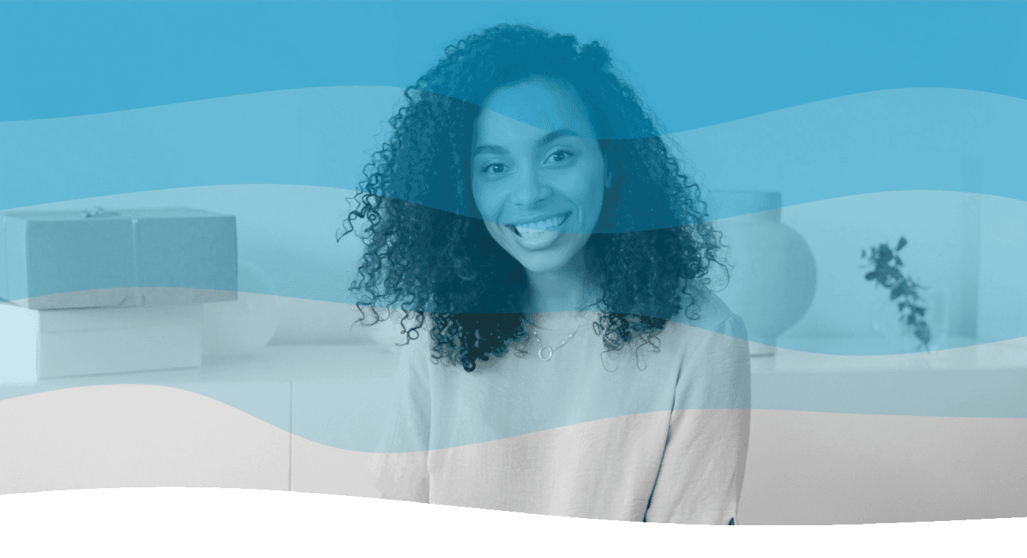 A person with curly hair smiles at the camera in a modern, minimalist room with decorative boxes and a potted plant blurred in the background, while a translucent blue wave filter overlays the image.