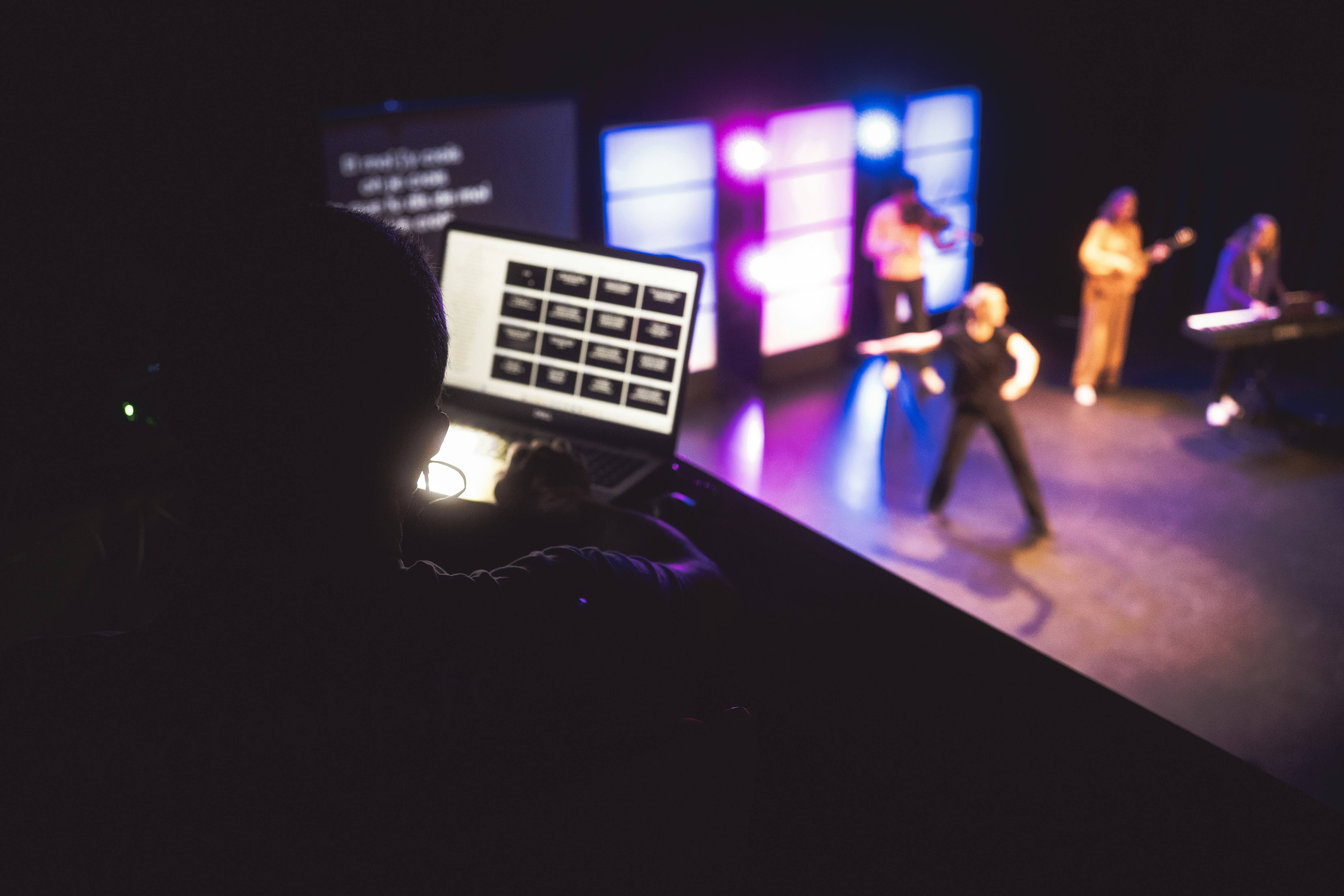 Musicians performing on stage with laptop control