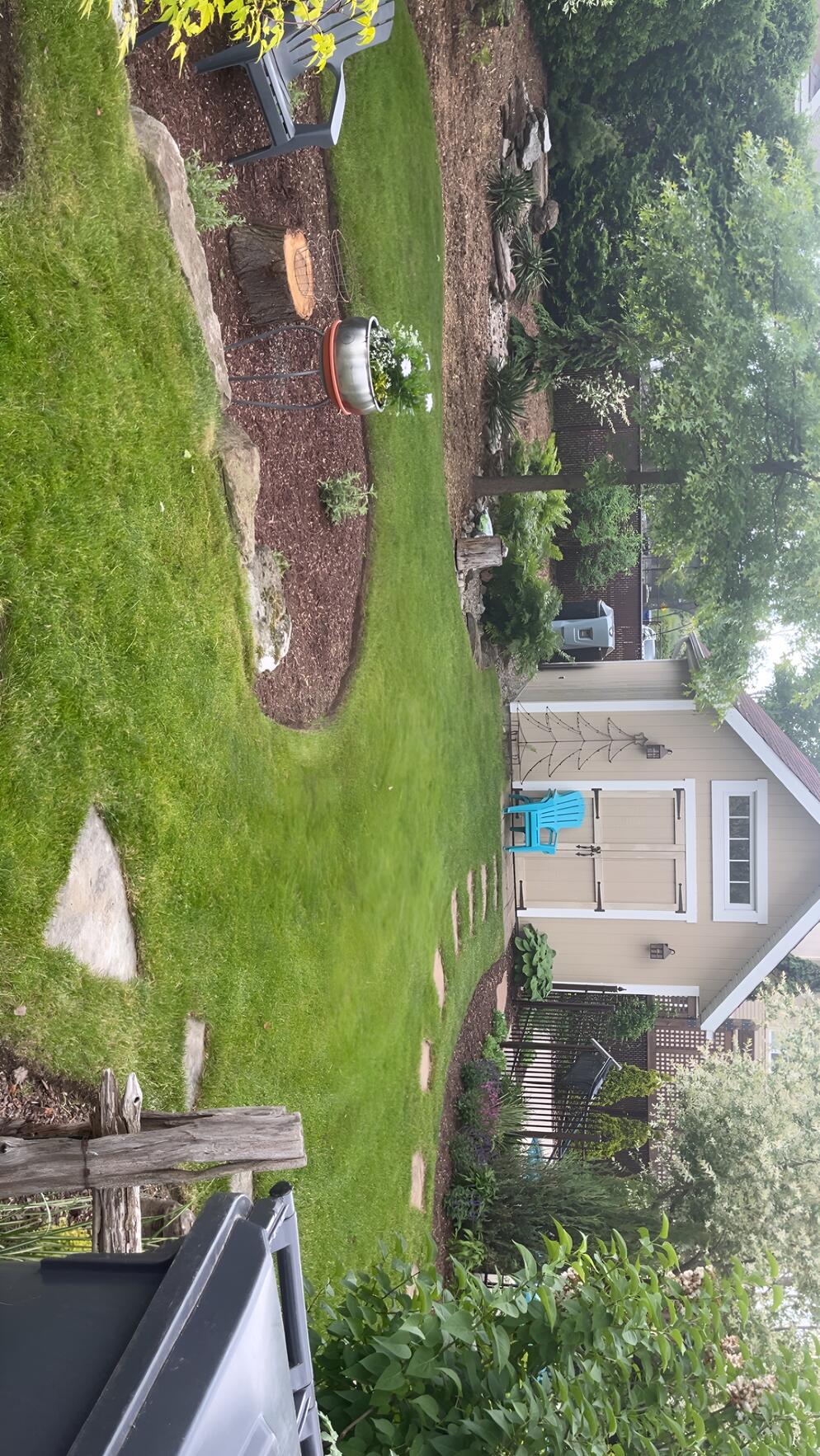 Aménagement paysager résidentiel avec pavé, plates-bandes et cabanon, réalisé par Pelouse Men Paysagement.